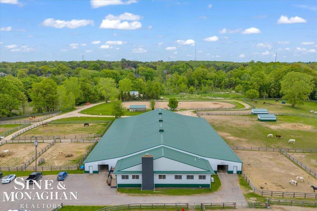 Set on over 24 beautifully maintained acres, this premier boarding facility-formerly a renowned hunter/jumper barn-has been completely renovated to meet the needs of modern equestrians. The mixed usage property combines both residential property and commercial zoning. Featuring expansive riding spaces, including a 110' x 240' outdoor arena and a spacious indoor arena. Recent upgrades include newly installed outdoor wash racks and perimeter fencing to elevate the functionality and safety of the grounds.  There are 14 well-appointed paddocks, each equipped with water, electricity, run-in sheds, and hay huts. Additional amenities include a pole barn for hay storage and a large enclosed shed that accommodates over 100 yards of shavings. A designated concrete manure collection area ensures clean and efficient waste management, while a new drainage system has been installed throughout the property for optimal land care.  Inside the barn, you'll find tack bays conveniently located in each aisle, multiple tack rooms, matted stalls with operable windows, and a spacious grain room. Recent additions include a brand-new observation room equipped with modern comforts such as heating, air conditioning, a washer/dryer, full kitchen, coffee bar, cozy lounge area, stone fireplace, and a flat-screen TV.  The facility also offers a professional reception area and a generously sized back office. Throughout the barn and arena, paneled ceilings with new LED lighting create a bright and inviting atmosphere, complemented by a state-of-the-art sound system for seamless communication and entertainment. Current tenants run the business completely seperate from the real estate sale of the property and would love to continue successfully running the full barn. Any future buyer would act as the land lord and would only need to cover insurance and taxes if this so appeals to them.