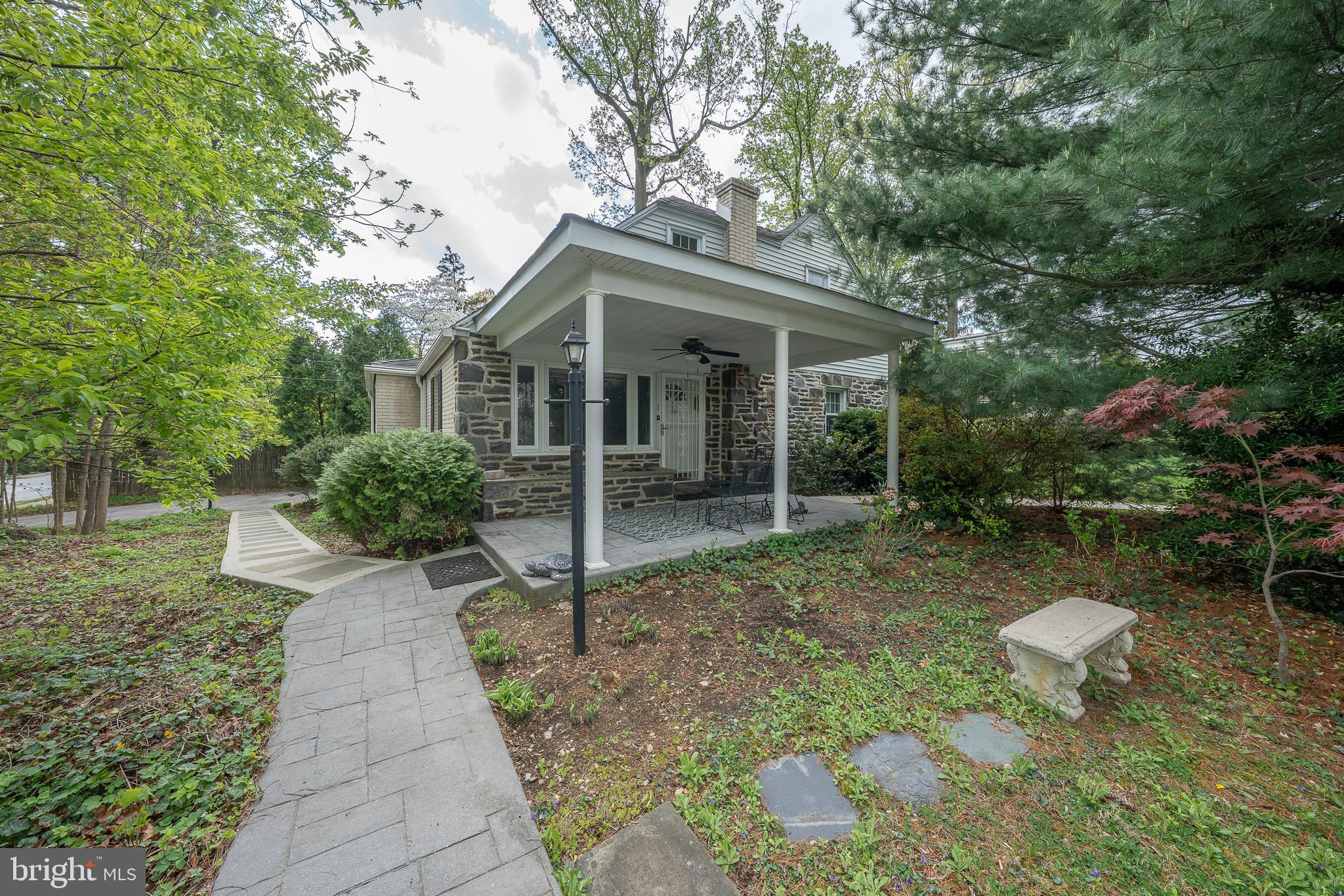 Don't miss this RARE opportunity to live in sought after neighborhood nestled between Villanova University campus and the R5 Rosemont train station. Walk up to the inviting large covered front patio to enter the front door. The main entrance leads into the spacious living room /dining area with large picture window. There have been many family dinners and parties in this dining area, and it is large enough to fit a full formal dining room set.  The dining area is adjacent to the oversized kitchen with counter height seating.  Cabinets with pull out shelves in this section.   The painted brick wall is the backdrop for another eating area.  Double windows overlook spacious side yard with rear door access to an oversized driveway.   There is also a half bath conveniently located adjacent to the kitchen.  There is a pocket door from the LR leading to the first-floor bedroom area.  There is a large oversized tiled full bath in the hall with extensive cabinetry.  This hallway leads to the large corner bedroom with walk in closet with a window.  There is another bedroom facing the front of the house.  This area could be easily modified to a private FIRST floor primary bedroom suite.The stairs leading to second floor are in the living room near the front door.  These hardwood stairs lead to two  nicely sized bedrooms and a hall bath with oversized walk-in stall shower.  There is an exterior door leading to second floor deck and outside staircase leading to side yard, offering private access.  Perfect for in-laws, adult children, etc.Both floors have the original hardwood floors throughout.Returning to main floor there is access to the partially finished basement.   The basement is heated with several spaces, perfect for exercise and/or play area, workshop, etc.  There is a separate utility room.  The washer/dryer is in the basement and there is anoutside entrance.