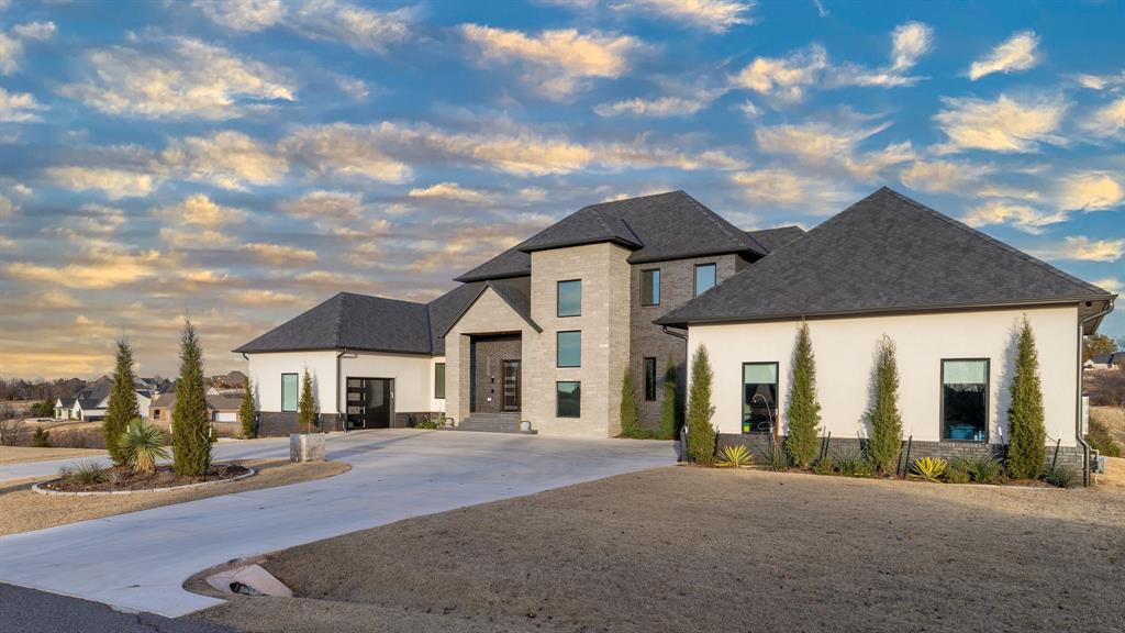 Set on nearly 2 acres within one of Norman’s exclusive gated enclaves, this striking three story estate blends modern architecture with refined, livable luxury. Sleek design, purposeful details, and a natural flow come together to create a home that feels both sophisticated and welcoming. At the heart of the home, the centrally positioned chef’s kitchen is a true showpiece featuring dual oversized islands, custom cabinetry, and a stunning marble vent hood and backsplash that anchors the space with sophistication. Designed for both everyday living and elevated entertaining, every detail has been thoughtfully curated. With over five spacious bedrooms, each having its own bathroom, this home provides comfort and privacy for family and guests alike. An upstairs living area creates the perfect retreat, while the walk out basement expands your lifestyle with a fully equipped second kitchen, private gym, game room, and a state of the art theater complete with acoustic paneling, surround sound and a professional grade projection system for an immersive experience.Step outside to take in sweeping views from the main level balcony or unwind on the lower patios as the landscape gently slopes toward a shared pond stocked with fish. Whether it’s paddle boarding at sunset or designing your own dock, pool or landscaping project this property offers a rare opportunity to create a true outdoor retreat.A home where luxury meets possibility this is a standout offering in one of Norman’s most sought after communities.