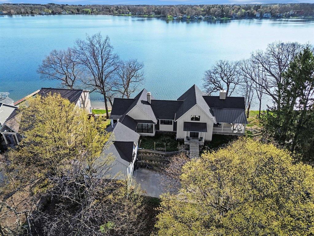 This newly completed custom home (2024) on Cavanaugh Lake, captures something that is exceptionally difficult to replicate--over 140 feet of frontage, panoramic lake views from every room, and a level of scale and versatility rarely found on the water.From the moment you enter, a full wall of glass draws you directly to the lake. The elevated setting provides a sweeping vantage point--expansive, unobstructed, and constantly shifting with the light, culminating each evening in vivid, colorful sunsets reflected across the water.The main level spans over 3,600 square feet, designed for both effortless daily living and elevated entertaining. The kitchen and great room flow seamlessly, anchored by a fireplace and framed by the view. A walk-in butler's pantry with additional sink enhances functionality, while a private office offers a quiet, dedicated workspace.Positioned above the entry, the open loft overlooks the great room and frames views of both the lake and front of the home.Currently used as an artist studio, it offers a flexible space equally suited for a library, lounge, or creative retreat.The primary suite is positioned to fully embrace the setting, complete with a generous bath, walk-in closet, and its own washer and dryer--creating a true private retreat within the home.Outdoor living is equally intentional, offering multiple distinct spaces to take in the lake. An expansive covered patio extends directly from the great room, creating a natural gathering space. In addition, a large composite deck and lower-level patio provide even more options for entertaining or quiet moments, all leading down to the dock--perfect for ending the day lakeside as the sun sets in striking color.The lower level adds over 2,600 square feet of living space, including three bedrooms, a theater room, second fireplace, expansive gathering area, kitchenette, and extensive storage for all your lake essentials.And just when you think this property can't get any better, a feature that truly sets this property apart: a separate, f