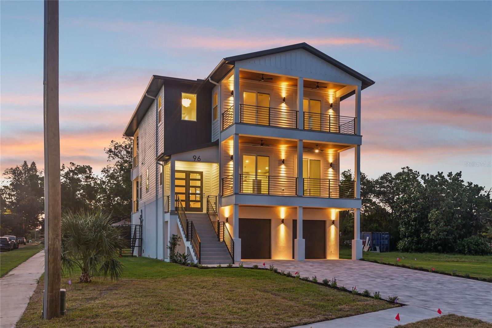 Experience breathtaking coastal luxury at 96 Shore Drive, a fully completed, move-in-ready brand new construction estate offering sweeping Gulf water views lot just steps from Sunset Beach. With 3,310 square feet of beautifully finished living space and an impressive 5,586 total square feet under roof, this home delivers the scale, craftsmanship, and elevated coastal lifestyle most can only imagine. The massive ground-level garage has room for more than four vehicles, golf carts, recreational equipment, and extensive storage space. A private interior staircase leads from the garage into the foyer and main living area, where a bright, open floorplan draws your attention toward the stunning water views. At the heart of the home, the showpiece kitchen features custom all-wood cabinetry with inset doors and drawers, quartz countertops with dramatic waterfall edges, a marble backsplash, and a top-of-the-line luxury appliance suite. The full walk-in butler’s pantry includes a second sink, additional cabinetry, dedicated storage, and beautiful open shelving, keeping the main kitchen effortlessly organized and ready for entertaining. Expansive covered balconies on both the main living level and third floor capture panoramic Gulf views, coastal breezes, and spectacular sunsets, creating an exceptional outdoor atmosphere for dining, entertaining, or simply taking in the surroundings. The spacious primary suite and junior suite each feature a luxury private en-suite bath. Every additional bedroom is generously sized and includes its own walk-in closet. Two of the third-level guest bedrooms open directly onto a sweeping front balcony, giving family and guests front-row views of breathtaking sunsets over the Gulf. The bathrooms are equally impressive, with floor-to-ceiling luxury porcelain tile, custom all-wood vanities, premium Delta fixtures, and illuminated mirrors with built-in defogging. Designed to pair refined finishes with lasting coastal performance and peace of mind, the home is supported by a deep foundation system and protected by premium Pella impact-rated windows, impact-glass doors, and a reinforced metal roof. With Sunset Beach just outside your door and Downtown Tarpon Springs, the Historic Sponge Docks, waterfront dining, shopping, and year-round community events only minutes away, 96 Shore Drive is a truly distinctive new home that brings together elevated design, exceptional space, and the very best of Florida’s Gulf Coast lifestyle.