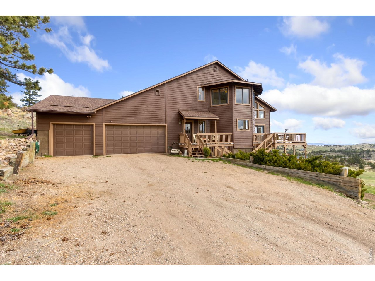 Discover the ultimate Colorado retreat on this sprawling 5.8 acre lot, located just 30 minutes from the heart of Fort Collins and a quick drive to Red Feather Lakes! Zoned for horses, this beautiful property is ready for its next owner. Enjoy over 3,200 sq. ft. of living space in this mountain home that perfectly captures the balance of modern convenience and natural escape. The main level is the heart of the home, featuring an open concept kitchen complete with maple cabinetry, a center island, and expansive windows. Two separate doors lead from the kitchen into a spectacular sunroom with soaring ceilings and venting skylights that invite the mountain breeze inside. Nearby, a sun-drenched dining nook, a cozy fireplace in the living room, and a convenient laundry room complete the main living area. Retreat upstairs to the primary suite, where you'll be welcomed by more beautiful views, a private bath, and a walk-in closet. Another bedroom and guest bath round out this level. Downstairs, the walkout basement offers even more flexibility with a large family room, another bedroom, and a second sunroom. Outside, the massive wraparound decks offer front row seats to our incredible Colorado sky. In addition, this property offers an oversized 3-car attached garage for all your gear and toys! With professional fire mitigation completed in January 2025, this home is as secure as it is beautiful.