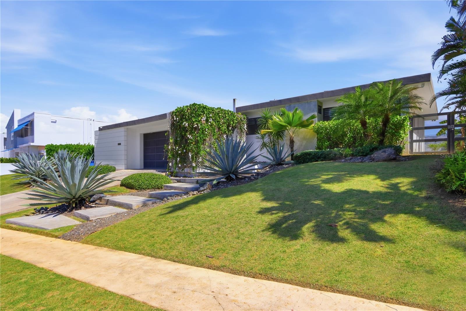 Located in the gated community of San Francisco in San Juan, this one-level residence offers the layout and scale today’s buyers are seeking. Set on a flat 1,200 square meter lot, the property provides both immediate comfort and long-term potential.The interior features 4 bedrooms and 2 bathrooms, complemented by high ceilings and generous natural light throughout. The kitchen is spacious and bright, designed as the central gathering space of the home, with seamless connection to the patio and outdoor areas.A dedicated wine cellar with capacity for approximately 300 bottles adds a distinctive touch for collectors and entertainers alike. The property also includes solar panels for energy efficiency and a flexible bonus room currently used as a gym, with independent access from the lateral patio—ideal for a studio, office, or guest suite. The expansive lot allows room for future expansion and outdoor enhancements while maintaining privacy and functionality. Solid construction, well-proportioned spaces, and a desirable floor plan create a residence that supports both everyday living and future customization.San Francisco is one of San Juan’s most in-demand gated neighborhoods, known for its location, accessibility, and established residential character. CRIM: $637 semester HOA: $238 monthly