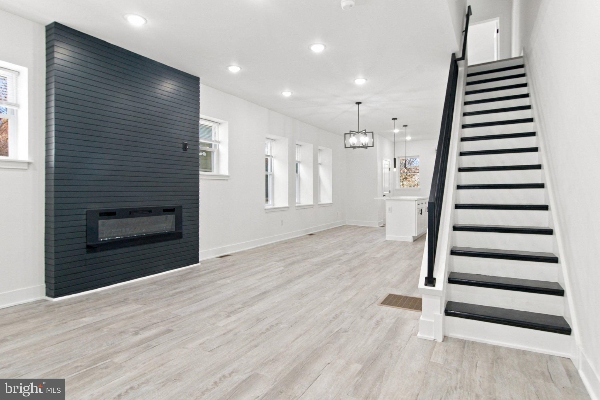 Welcome to this thoughtfully renovated home, featuring top-to-bottom upgrades and sleek LVP flooring throughout. Enter through a bright, spacious sunroom flooded with natural light—an ideal spot for a morning coffee or a reading nook. Step further into the main level, where an open-concept layout seamlessly connects the living room, dining area, and kitchen. An electric fireplace serves as the focal point of the living space, while abundant large windows fill the entire main floor with sunlight.The kitchen is designed for gathering and everyday cooking, complete with a large island with a breakfast bar, quartz countertops, stainless steel appliances, and extensive cabinetry. A main-floor powder room adds extra convenience, and toward the rear of the home, you will find a dedicated laundry area along with access to the back patio.The second floor hosts two spacious bedrooms and two full bathrooms. The rear bedroom features ample natural light and a generous closet. A full hallway bathroom serves this level, complete with an oversized vanity and a tub/shower combo. Positioned as a true primary suite, the front bedroom offers great light and a walk-in closet that leads directly into a private en-suite bathroom, also featuring an oversized vanity and a tub/shower combo.The third floor provides two additional well-proportioned bedrooms alongside another full bathroom, offering plenty of flexibility for guest space, a home office, or extra living area.Outside, the fully fenced rear patio provides privacy and plenty of room for outdoor dining and entertaining. Downstairs, the unfinished basement offers reliable, out-of-the-way storage space.Located just minutes from the restaurants and shopping along Baltimore Avenue, the green space and community events of Clark Park, and the universities, hospitals, and amenities of University City. Commuting is effortless with nearby SEPTA trolley lines, bus routes, regional rail service, and convenient access to Center City Philadelphia and major roadways.