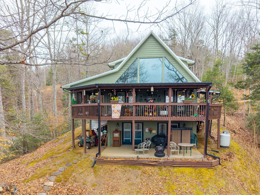 Come home to this 2-bedroom 3-bathroom chalet with bonus room with easy access to Murphy, NC and Blairsville, GA.   This spacious home features a living room/dining room combo, kitchen with granite countertops and tiled back splash.  A bedroom with walk-in closet, full bath and washer/dry area on the main floor. You will enjoy many quiet mornings and evenings relaxing on your large back-covered deck, Upstairs offers a separate sitting area, large bedroom and spacious bathroom.  The lower-level basement has an open area with another bonus room and full bathroom.  Doors from the basement lead to a slab patio for more outdoor enjoyment and access to your firepit.   New metal roof was installed in 2022 and HVAC was replaced in 2021.  Come and make this home your own.