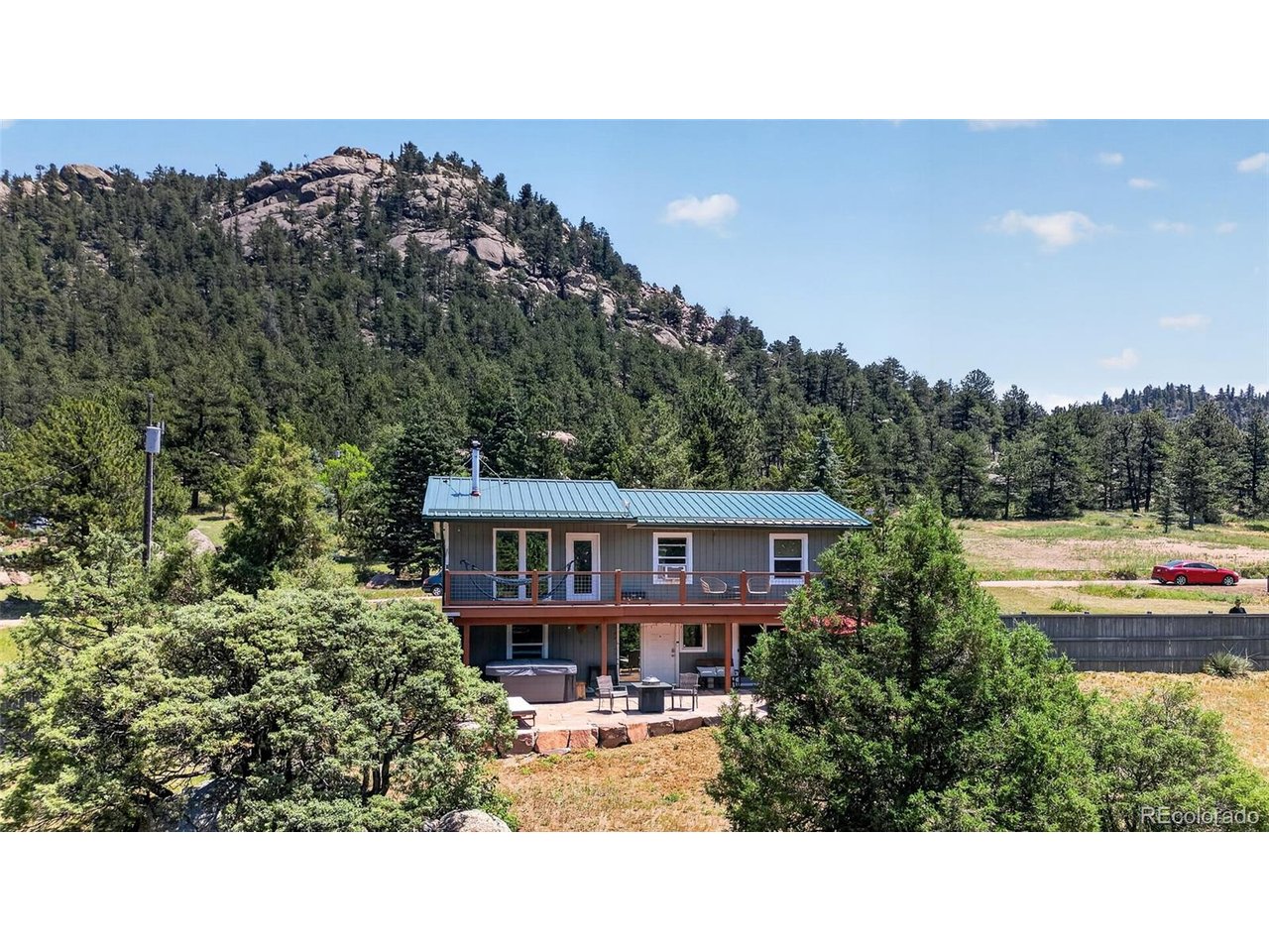 Stunning Views, Upgrades & Ultimate Privacy with National Forest in every direction! Nestled in the mountains of Lyons, this beautiful home offers breathtaking scenery, and the Colorado lifestyle you've been dreaming of. The open floor plan is filled with natural light thanks to picture windows showcasing the forest from every room. The remodeled kitchen features updated cabinetry, modern finishes & newer appliances, while beautiful wood flooring and exposed brick in the bathroom create a warm, contemporary feel throughout. Step out onto the new decks and create the perfect place to enjoy your coffee, entertain friends, or unwind while taking in the surroundings. Plus, enjoy the massive, locally sourced Lyons Sandstone patio and retaining wall, complete with a new hot tub and new pergola for extra privacy; multiple outdoor gathering spaces that blend seamlessly with the natural landscape. A fully fenced yard offers room for pets & recreation all while maintaining privacy. A 1,000 gallon rain collecting cistern makes gardening a cinch. The spacious walkout basement features a bedroom w/ ensuite & family room with up/down blinds; ideal for guests, multi-gen living & flex space. This home offers peace of mind! Major improvements; new metal roof, front door, exterior paint, windows, electrical panel, water heater, water line, and a newer fence. With so many significant upgrades completed, you can simply move in & enjoy mountain life. Adventure begins outside your door w/ nearby trails, wildlife and endless opportunities for outdoor recreation. You'll enjoy a level driveway with year round access to US 36, high speed internet(fiber optics recently added along US 36), just 10 min to Lyons, 15 to Estes Park & 30 to Boulder. Whether you're looking for a full time residence, mountain retreat, or the perfect place to embrace Colorado's outdoor lifestyle, this exceptional home delivers the combination of privacy, modern updates, stunning views, and unbeatable access to nature.