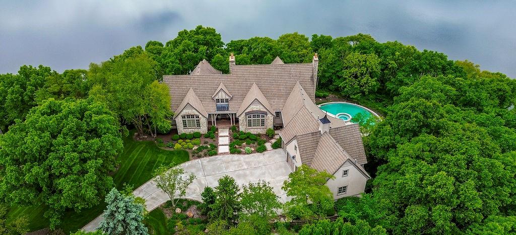The premier lake-front property in the North Shore Estates neighborhood of Cedar Creek!  Tucked deep off the street @ the end of a cul-de-sac, this authentic European Manor offers the ultimate in privacy & architectural presence.  Extensive natural limestone exterior trimmed in aged paver brick and boasting an over-sized 4-car garage that includes a suspended floor slab over a fully excavated basement storage space below!  Enjoy stunning panoramic views overlooking Shadow Lake & the Cedar Creek valley from the rounded infinity edge pool & outdoor oasis w/built-in outdoor fireplace!  12' ft. foundation walls, 8' ft. solid wood doors, 3-zones of high efficiency HVAC, silent floor joists & tile roof!  Open concept floor plan features adjoining Great rm., casual dining & kitchen with vaulted beamed ceilings and convenient front & back stairs!  Wide plank, premium oak hardwood & neutral 2' x 2' travertine flooring. Luxurious main floor primary suite walks out to a covered paver brick porch overlooking the lake, custom walk-in shower with 2-heads, separate tub & huge walk-in closet.  1st floor also includes a spacious formal dining rm., home office with a wall of custom built-in cherry cabinetry & beautiful Sun rm. w/brick flooring.  Finished walkout lower level consists of Family rm. w/FP, Rec rm. w/wet bar/kitchen, 3 big bedrooms, 2 full & 1 half baths. Note the expansive room sizes throughout this home that resides in the DeSoto school district but with an option to apply for enrollment to Olathe schools also.