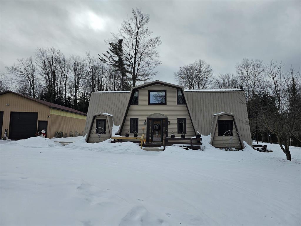 Situated on 5.4 acres just west of Hale in Ogemaw County, this distinctive Northern Michigan property offers an exceptional combination of privacy, utility, and natural surroundings. The lower level includes two bedrooms, a full bathroom, kitchen, dining area, laundry facilities, and a living room. The upper floor features a spacious family room with wet bar and half bath, as well as a master suite. Exterior amenities include a garage/workshop with an 18-foot lean-to and a 26 x 56 pole barn equipped with a 12 x 12 mezzanine offering ample storage space. The mostly wooded property also contains a small pond. Additional highlights include an encapsulated and insulated crawl space, a newer furnace, and 220-volt electrical service in both the pole barn and garage. Multiple decks and balconies provide ideal vantage points for enjoying the surrounding wildlife.