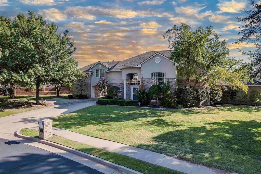 Welcome to 2701 SW 121st Street in the prestigious gated community of Rivendell on the Lake— New roof installed! Just minutes from Will Rogers World Airport, dining, and shopping. This impressive 2-story brick and stucco home offers 4,182 square feet of thoughtfully designed living space with 4 bedrooms, 3.5 bathrooms, and a 3-car garage with an additional port-a-cove for extra covered parking. Inside, you’ll find a grand, oversized main living room with a gas fireplace — perfect for cozy evenings — a formal dining room, and a formal living area accented with art niche cutouts. Just off the dining room, a convenient wet bar makes serving guests effortless. A cozy reading nook with built-in bookshelves sits off the staircase landing, creating the perfect retreat. The primary suite offers an electric fireplace for added ambience, direct access to the back patio, a large jetted tub, a spacious walk-in closet with custom built-ins, and abundant cabinet storage. Secondary bedrooms are all generously sized, including one approximately 17'7" x 15'5", another around 16'10" x 15'9", and the third approximately 12' x 13'8". Two of these bedrooms also feature attached bonus rooms that can be used as offices, hobby rooms, or expanded closets. The kitchen is well-appointed and all appliances remain, including a brand-new dishwasher. A large laundry room provides ample storage and workspace. The covered back porch with skylight creates a relaxing outdoor retreat, complete with an outdoor kitchen featuring a stovetop and counter space — perfect for weekend cookouts. Additional highlights include a spacious 16,988-sq-ft lot and the security of a gated community with a prime location offering easy access to major highways and the airport.