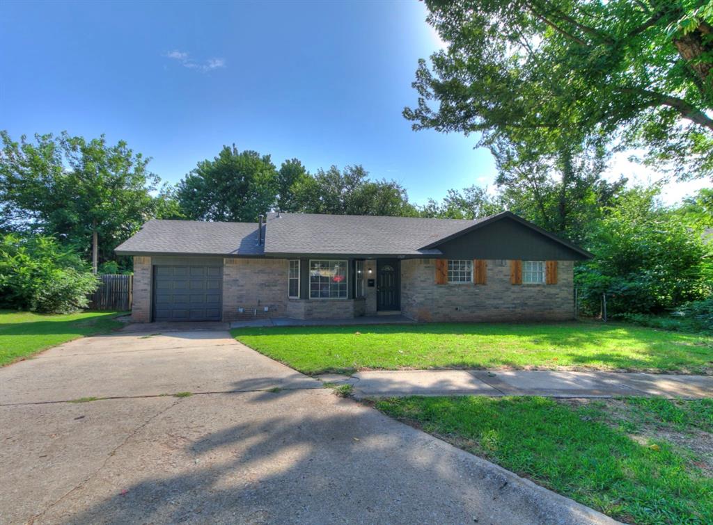 Welcome to this charming, move-in-ready brick ranch home that perfectly blends classic character with modern updates! From the moment you arrive, you will love the excellent curb appeal, highlighted by a large front yard, mature trees, and warm wood shutter accents. Step inside to find a beautifully updated interior featuring fresh neutral paint and durable, modern luxury vinyl plank flooring stretching through the main living spaces and bedrooms. The heart of the home is an expansive, light-filled living room boasting tray ceiling, a floor-to-ceiling stone fireplace, and a custom built-in —making it the perfect hub for entertaining or relaxing. The layout flows effortlessly into the kitchen equipped with crisp white cabinetry, granite countertops, and   stainless steel appliances, plus an adjoining tiled dining area. The home offers comfortable bedrooms with modern ceiling fans, and large windows that fill the rooms with natural light. A dedicated laundry room with overhead storage adds extra convenience. The outdoor space is a true retreat! Step through the French doors onto a sprawling wooden back deck that overlooks the shaded backyard surrounded by mature trees—offering ultimate privacy and the perfect backdrop for outdoor gatherings, gardening, or playtime. Complete with an attached garage, this beautiful home is ready for its next owner. Schedule your tour today before it's gone!