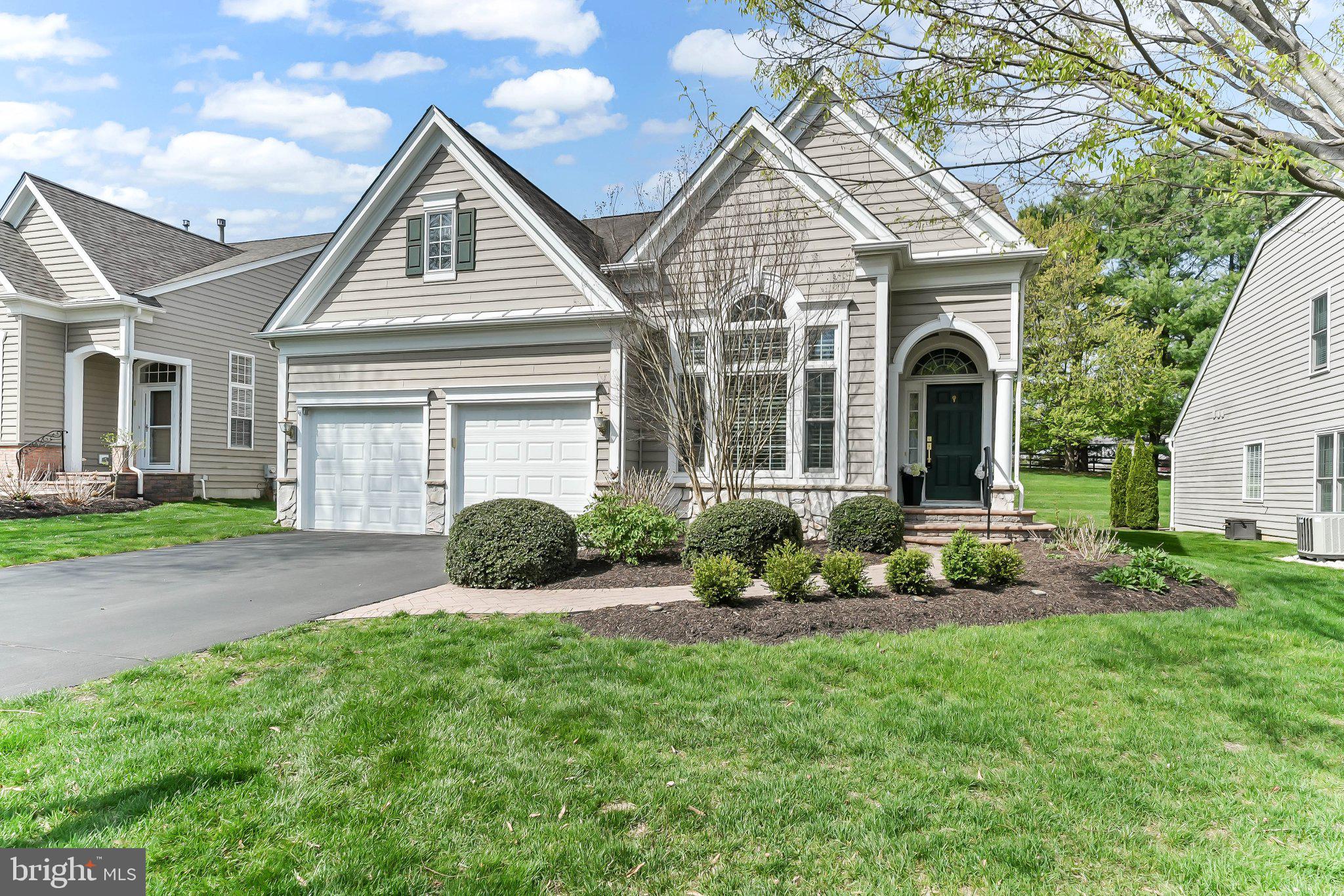 This is the one that you have been waiting for! Located in Chester County's premier 55+ Gold Star community, Traditions at Longwood, this meticulously maintained home is close to Longwood Gardens, Downtown Kennett Square, Chadds Ford, Glen Mills, Greenville, Wilmington, Newark, Philadelphia, Philadelphia Airport, Baltimore, the Brandywine River & Museum, Whole Foods, Wegmans, The Fresh Market, Trader Joe's, numerous retail stores, restaurants, nature parks, trails, PA Wine Trail & vineyards, birding, golf courses, horseback riding and so much more. Within the community, you can enjoy the community garden, pools, tennis, pickle ball, walking trails, etc. This particular home is located in the desirable PHASE 1 of this community and occupies a PREMIUM LOT along the quiet inner perimeter of the community; one that affords serene privacy and beautiful views of trees from the outdoor living space. This is a 2BR Newhall model without the upstairs loft and third bedroom/bathroom.  This home has a completely renovated stunning kitchen, and newly refinished hardwood floors on the main level. From the time you pull up to the home, to the time you complete your tour, you will be impressed with the immaculate condition of the property, the lovely hardscaping, the wonderful molding and architectural details throughout, and the upgraded fixtures and finishes. The formal living room is located just off the main entry and it is generously sized and boasts a tray ceiling. The formal Dining Room is just beyond and it has a stunning, upgraded chandelier and lovely wainscoting and moldings. The kitchen is fully open to the family room, a beautiful light filled window, stainless steel appliances, upgraded leathered granite counter tops, gorgeous handmade white subway tiles, a pantry closet,  and plenty of eat-in space. The family room just beyond has a marble, natural gas fueled fireplace with an exit to the outdoor, hardscaped patio space. which runs the length of the home and provides a wonderful place to sit and enjoy the wooded trees beyond and the backyard.  The primary bedroom and bathroom are conveniently located in the back of the home with a gorgeous picture window that frames the stunning views behind the home perfectly. The primary bedroom has a sitting area, a large walk-in closet plus a wonderful en-suite bathroom with a large tub, separate stall shower, separate toilet room, and a long double sink vanity. The main floor also has the laundry room and full bathroom located near the kitchen and dining rooms plus the second bedroom.  This home has upgraded finishes such as hardwood and tile floors throughout and wonderful custom columns, panel box molding, crown molding, arches, and ceiling details in many of the rooms. Traditions at Longwood has some of the nicest amenities of any over 55 community in the area: two clubhouses, a beautiful community pool with plenty of seating and a lovely pergola covered area, a community garden area, tennis courts, pickellball courts, bocce court and a billiard and card room, plus plenty of scheduled activities and community events. The HOA takes care of everything: grass cutting, flower beds, snow removal on driveway, front walkway/steps & streets, trash, recycling, clubhouse, library, social/events room, fitness center, spa, sauna, common areas & a community pond with its own famous white swans. Make your appointment today to come see this lovely home. The finishes, condition, lot features and location make this a truly special home.