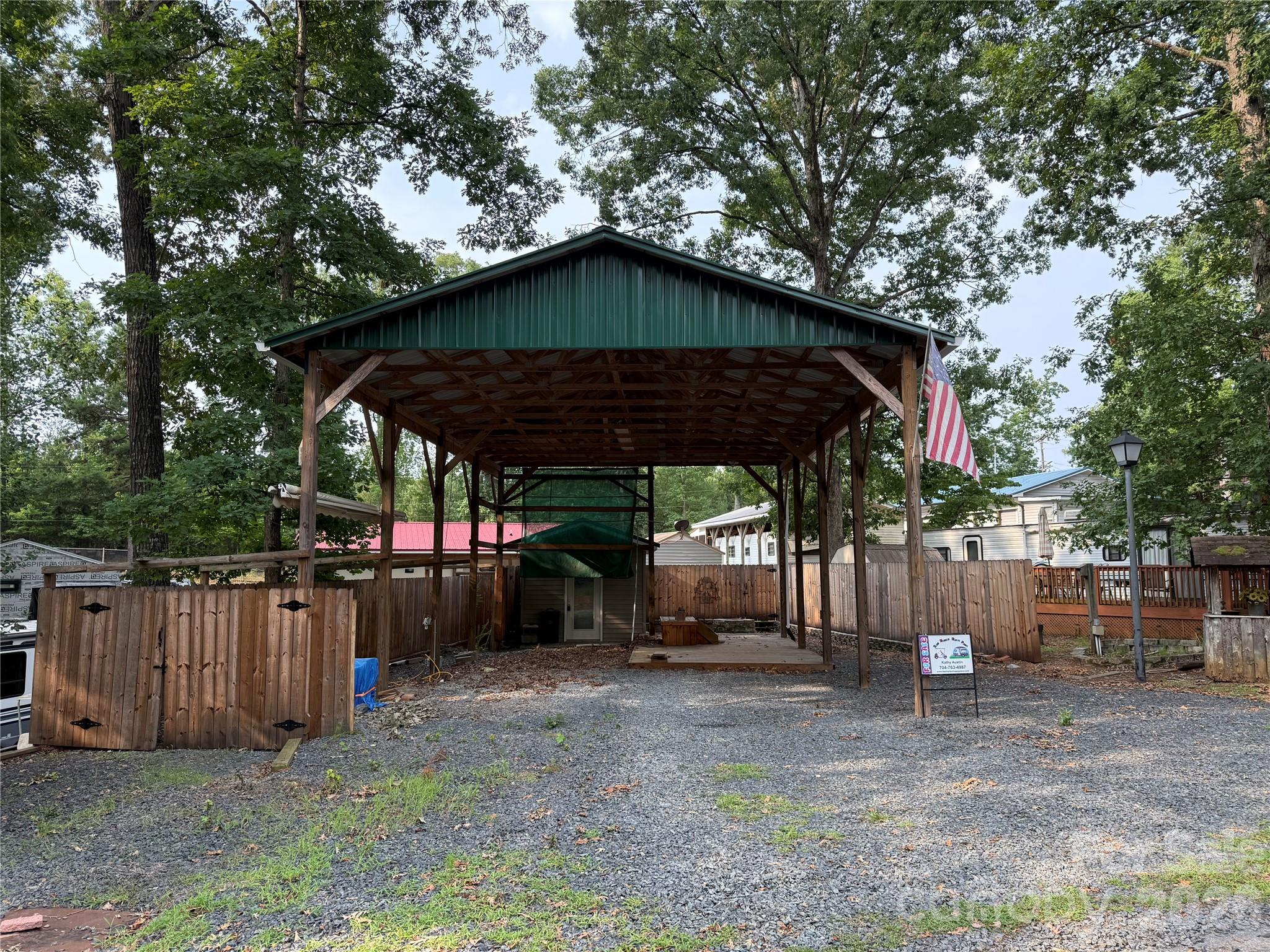 Rare opportunity for a great level lot with an awesome set up for you to bring the camper you already love. Structure is already there. It includes a deck, pull away stairs, fully insulated building with power and shelving. Additional elec hook up for a secondary camper to stay for short visits. Partially fenced with an area to park a car, golf cart, jet ski behind a locked gate and a fire pit. All buyers must be with a realtor to gain access to the community.