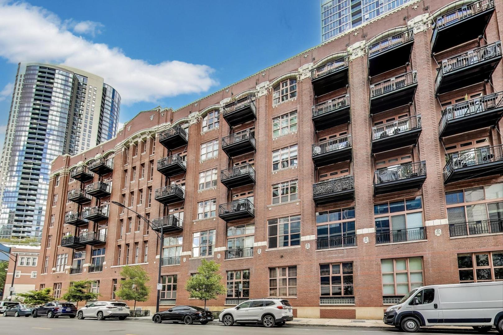 Right in the heart of River North at the Sexton you'll find this timber loft corner condo that is flooded with natural light. The home is the perfect blend of vintage charm with modern updates. The high ceilings, wood beams, original brick are accented by freshly painted walls. The open kitchen was recently updated with some new appliances and includes a 4-burner Viking stove top, large island for entertaining and additional pantry space. The size of the primary bedroom and custom walk-in closet is a step above other condos in the area. The updated oversized private bathroom includes a separate soaking tub and separate shower. The second bedroom, located on the other side of the loft, is adjacent to a 2nd full bathroom. Charming fireplace. As an added perk, the home features a full laundry room with side by side washer and dryer. There is a deck that overlooks the East Bank Club. One covered parking spot and storage unit is included. Dog friendly. Fitness center with Pelaton, free weights and treadmill. Receiving room, bike room and security. Close to everything you need and everything that makes River North a coveted address.