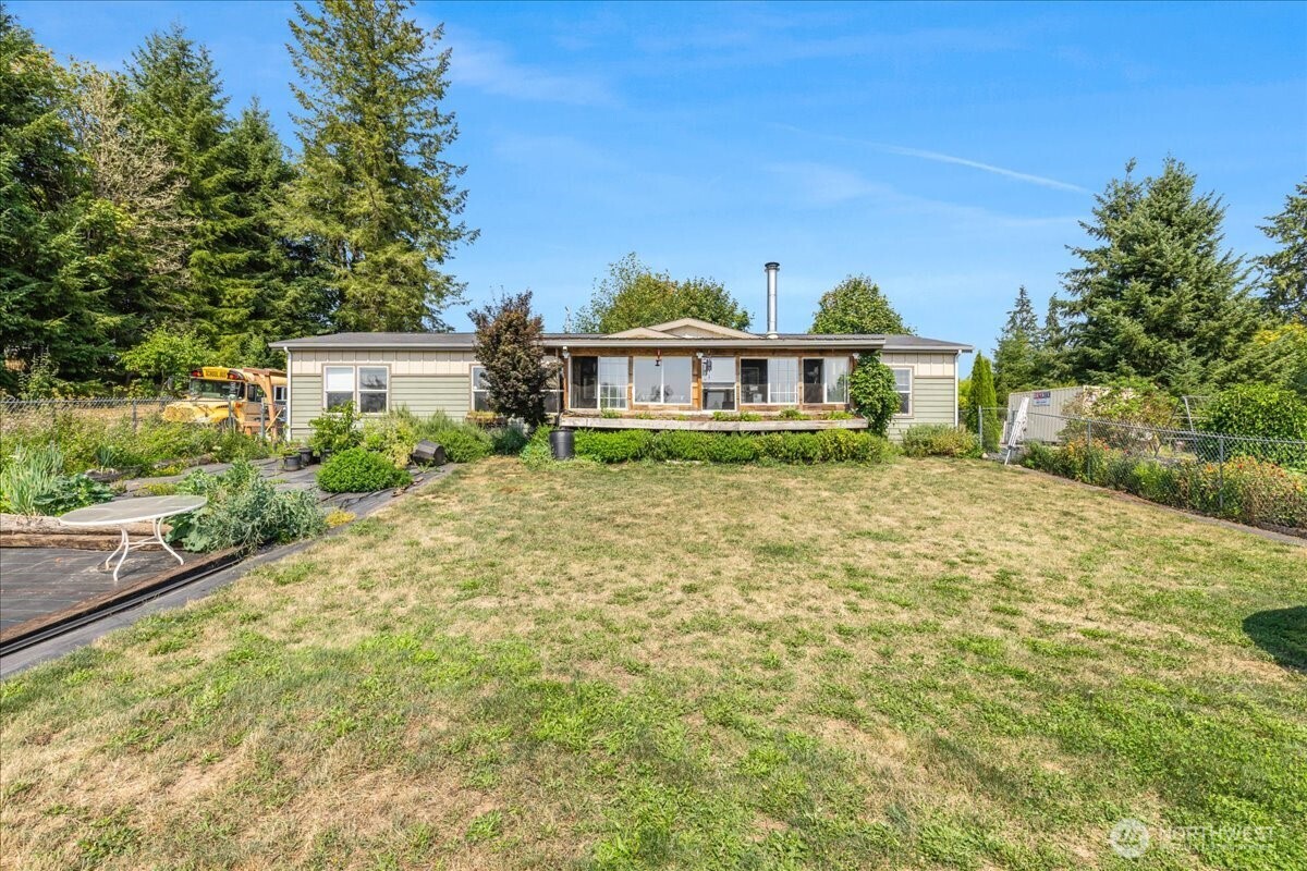 Welcome to your dream homestead! This 4bed , 2bth sits on 4.8acres is perfect for comfortable living. Enjoy the bounty of nine thriving 100% organic orchards, complete w/ irrigation, offering apples, pears, stone fruits, berries, and much more. 2 greenhouses 20X20 & 20X40, provide extended growing seasons. A container on the property for storage use, implement storage for firewood as well, forested acres with usable timber w/ manicured trails! Equipped with a barn for your farm animals! This home offers an imported cookstove from Spain which is ideal for those seeking a self-sustaining lifestyle! Enjoy the sunroom over-looking your views! Full orchards list attached. The fresh fruits, veggies, crops photos actual footage from current crops.