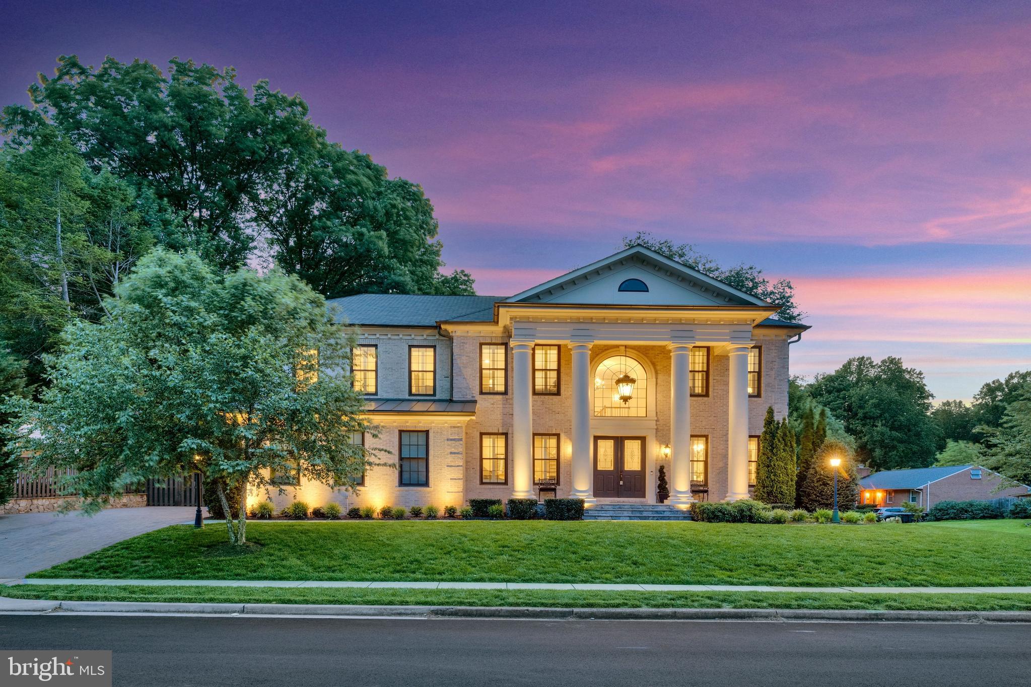 Just beyond the McLean border in the coveted enclave of Penguin Place, this exceptional Premier Homes estate offers an unparalleled blend of luxury, craftsmanship, and convenience. Ideally situated just minutes from McLean, Tysons, Falls Church City, Metro access, world-class shopping, dining, and major commuter routes. Distinguished by its stately architecture, the residence makes a grand first impression with soaring columns, intricate brick detailing, and a dramatic coachman’s chandelier. Inside, sophisticated living spaces unfold across multiple levels, highlighted by a sweeping curved staircase, sunlit rear staircase, main level bedroom/library, and ELEVATOR ACCESS to all 3 levels. Designed for both everyday living and grand-scale entertaining, the gourmet chef’s kitchen features an oversized center island, 2 dishwashers, warming drawer, wine fridge, sun-filled morning room, and an expansive great room anchored by a stunning double-sided fireplace to the screened pavilion porch. The luxurious owner’s retreat lives like a private penthouse, complete with a European-inspired spa bath, steam shower, radiant heated floors, dual water closets, one with bidet, 2 walk-in closets, fireplace, wet bar with refrigerator and ice maker, and private sleeping porch. The walkout lower-level rivals a private resort, offering a fitness center, steam shower, club room, game room, sports bar with dishwasher, microwave and wine fridge, fireproof safe room, and additional guest accommodations. More than $200,000 in PREMIUM ENHANCEMENTS, elevating both the indoor and outdoor living experience. There are 16 MOUNTED TVs THAT CONVEY, PLUS the home theatre (160 inch mounted backlit screen, Epson projector, and Denon surround sound system with built in speakers). Resort-style grounds showcase a custom in-ground spa with waterfall rock formations, extensive hardscaping, and a beautifully designed outdoor entertaining area. The outdoor kitchen is fully equipped with a Fire King grill, beverage center, warming drawer, trash drawer, and outdoor refrigeration. Additional upgrades include electrical car charger in the 2 car garage, built-in humidifier, air filtration system, full house GENERATOR, a rear roof awning, custom plantation shutters throughout, and a large-screen media center complemented by a custom sound and lighting system.