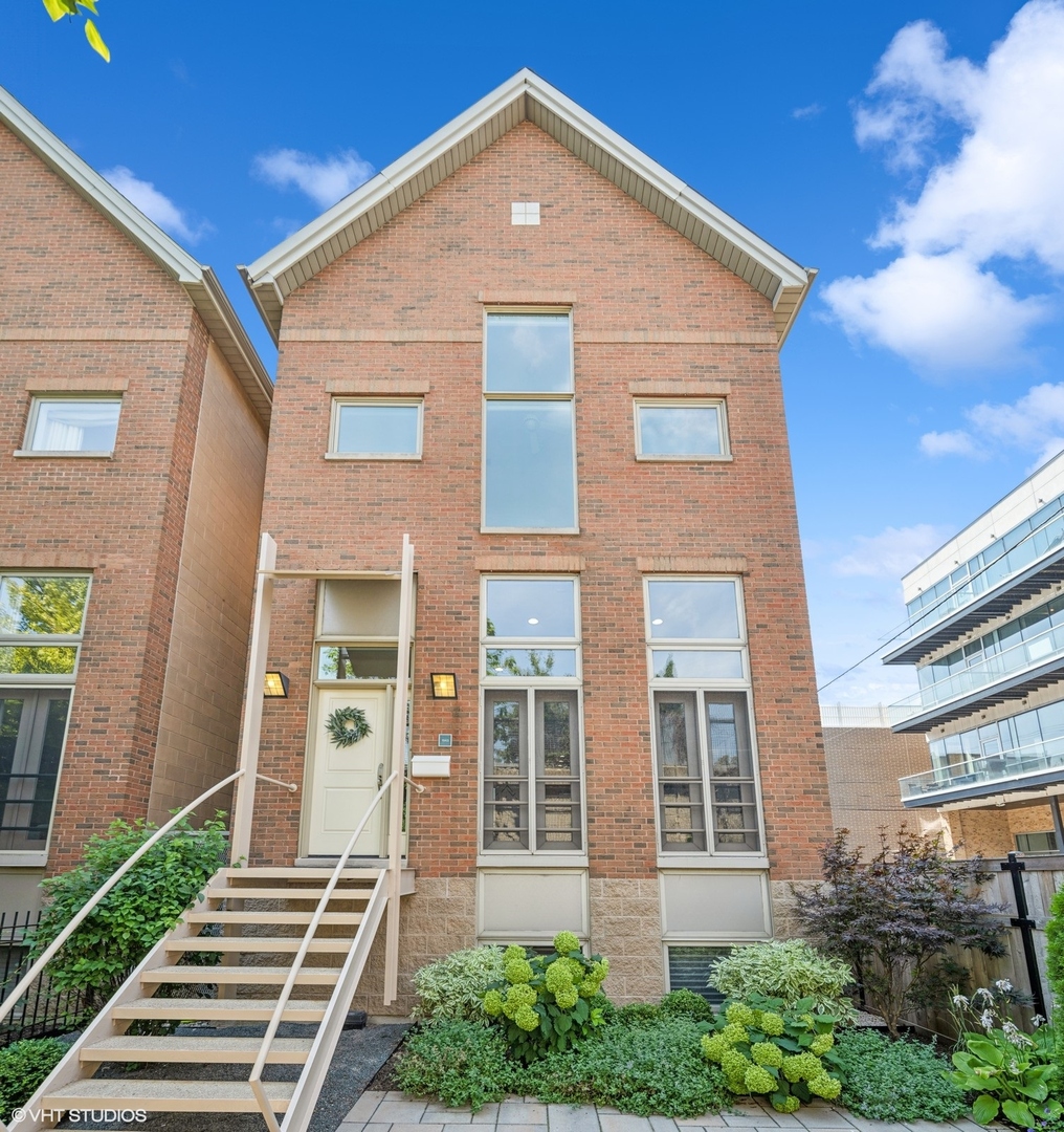 Sold Before Print. Experience the Best of Bucktown Living!  Step through a lush, professionally landscaped courtyard alongside the iconic 606 Trail and into something truly extraordinary. Welcome to 1943 W. Bloomingdale-the westernmost of just five exclusive fee-simple residences, offering an exceptionally wide floor plan, four exposures, and multiple private outdoor spaces across four stunning levels.  Your journey begins at a gated front patio, a serene retreat perfect for morning coffee or evening cocktails. Inside, a dramatic living and dining space stretches over 20 feet wide and 35 feet long, framed by soaring 12-foot ceilings and expansive windows that flood the room with natural light. A chic fireplace anchors the space, creating an inviting atmosphere for grand entertaining or quiet evenings in.  Just a few steps up, the gourmet kitchen offers stainless steel appliances, granite counters, and rich cherry shaker cabinetry. An eat-in breakfast area connects seamlessly to an upgraded deck with composite flooring, custom planters, and ambient low-voltage lighting-ideal for summer gatherings.  Upstairs, three bedrooms and two beautifully updated baths include a show-stopping primary suite with 18-foot ceilings, a full wall of windows overlooking the 606 and Churchill Park, his-and-hers California Closets, and a spa-like en suite with an oversized double vanity, frameless glass shower, bench seating, and dual shower heads.  The top level boasts a sunlit lofted flex room-perfect for a fourth bedroom, office, or media space-opening to a private rooftop oasis with composite decking, custom planters & specimen trees surrounding a natural gas fire pit.  The expansive lower level offers a large family room, full bath, laundry, and a California Closets-outfitted mudroom with direct access to the oversized attached two-car garage.  With over $400,000 in thoughtful improvements in the past decade, this rare home blends refined design with unbeatable location-just steps from the best shopping, dining, and nightlife in Bucktown and Wicker Park, plus direct access to the 2.7 mile 606 Trail!