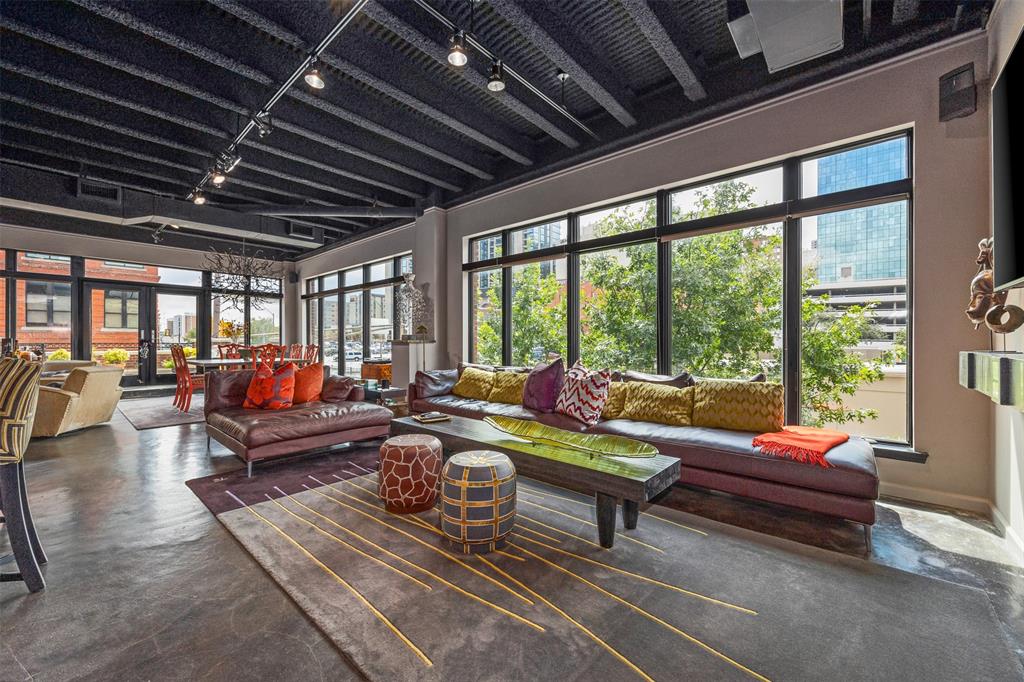 LISTING FOR 2ND FLOOR RESIDENTIAL CONDO ONLY. Discover a unique opportunity in the heart of downtown Fort Worth at The Granger Building, offering residential condo luxury. This meticulously designed two story urban property boasts stunning skyline views and unique, modern finishes throughout. The spacious condo features 3 bedrooms, 3 full baths, and one half bath. There are 3 elegant living areas that provide both comfort and style, with an additional space perfect for a study, offering work from home convenience. The open concept layout enhances the contemporary design, with sleek kitchen cabinetry and high end finishes creating a sophisticated, modern feel. Walls of windows provide natural light and striking views from every angle, with custom shades for privacy. Entertain or relax on the expansive rooftop patio with panoramic city views, perfect for enjoying the vibrant Fort Worth skyline. Enjoy entertainment at your fingertips and luxury details throughout. The building also includes a 2 car garage, ensuring convenience in this sought after urban location.