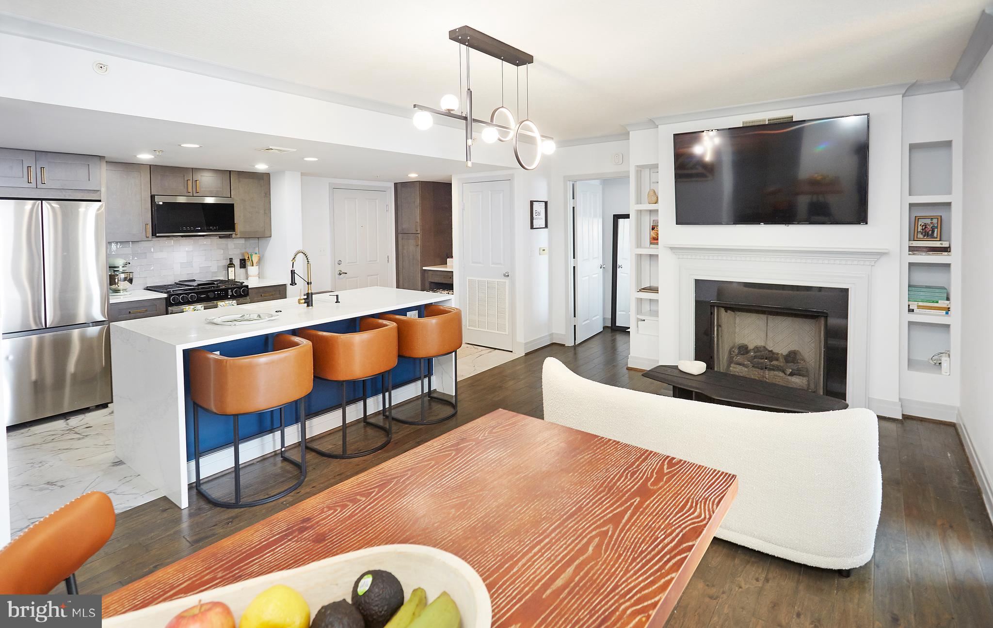 Welcome home to luxury waterfront living in the heart of downtown Baltimore! This beautifully remodeled 2-bedroom, 2-bath condo combines modern elegance with unbeatable harbor views, offering the perfect blend of comfort, style, and convenience. Step inside to an open, light-filled layout featuring a spacious living area with custom built-ins and a cozy fire, hardwood floors, and designer lighting. The thoughtfully crafted kitchen offers quartz waterfall countertops, bespoke stainless-steel appliances, custom cabinetry, and a built-in chef's nook. Enjoy morning coffee or evening sunsets from your private balcony overlooking the water. Retreat to the serene primary suite, complete with a large walk-in closet and a spacious bathroom featuring traditional tiled shower, modern fixtures, and built-in nooks. The second bedroom offers versatility as a guest room, home office, or exercise room, paired with a simply updated full bath. Condo fees include all water and gas. With premium building amenities complete with a sunny rooftop pool and hot tub, fitness room, business center, in-building parking, and 24/7 concierge.  This prime location puts you steps from top restaurants, shopping, and attractions, including the Rash Field Phase 2 waterfront park development coming summer 2026. This home delivers the best of urban waterfront living at an unbeatable price. Move-in ready, tastefully transformed, and surrounded by all the excitement of downtown Baltimore.  This condo is truly a must-see!