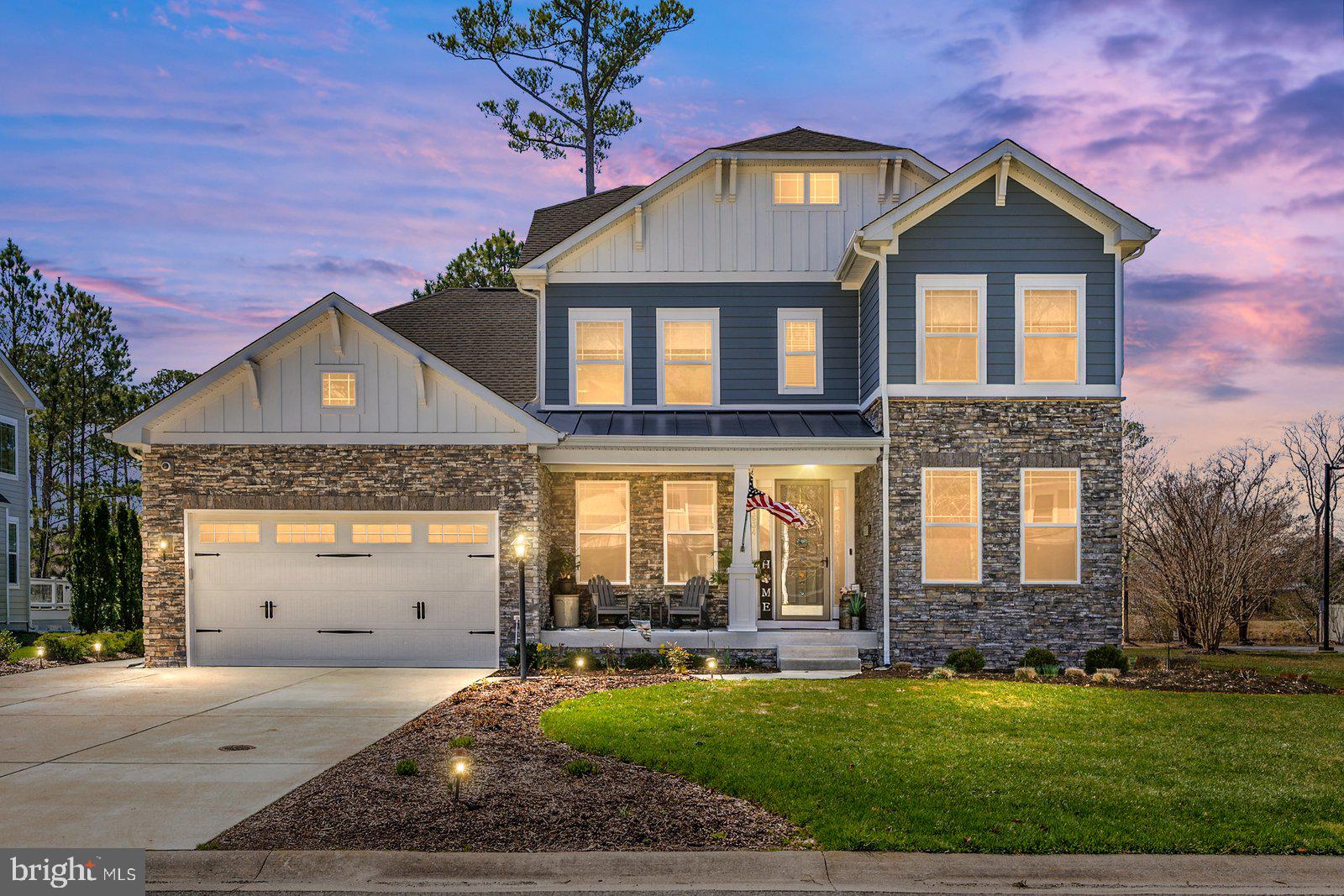 11634 Maid At Arms Ln, Berlin, MD — Built in 2019, this former model home offers over 3,100 sq ft of upgraded living space and is ideally located within the gated golf course community of GlenRiddle, in close proximity to clubhouse amenities. This 3BR, 2.5BA home features a spacious open layout with engineered hardwood flooring, hardwood stairs, walls enhanced with custom wood trim and decorative accents, and upgraded lighting fixtures throughout. The chef’s kitchen is designed for both function and style, featuring a large island, quartz countertops, stainless steel appliances, gas range with hood, double wall ovens, soft-close cabinetry, pull-out drawers, dishwasher, disposal, butler’s pantry, walk-in pantry, and abundant storage. Just off the kitchen is a casual dining area with French doors that open to the screened porch, creating an easy indoor-outdoor flow. The main living area is anchored by a gas fireplace with custom tile surround extending the full height and width, is flooded with natural light, and opens to a sun deck, creating a bright and inviting space for everyday living and entertaining. The primary suite includes a tray ceiling, plantation shutters, walk-in closet, dual vanity, and a spacious walk-in shower with multiple shower heads and ceramic tile, along with a private water closet. The second bedroom features custom hand-painted wall artwork, while the third bedroom offers a walk-in closet and additional storage. Additional interior features include a dedicated office, loft area, mudroom with built-ins, and a full laundry room with utility sink. Built for efficiency and durability, the home includes gas forced hot air with dual-zone HVAC, AprilAire dehumidifier, encapsulated and insulated crawl space with 4-ft height, interior access via door and steps, offering a large usable storage area, alarm system, and a garage equipped with a mini-split HVAC system, recessed lighting, and side entry door. The exterior showcases a combination of stone and siding, a decorative garage door, and a welcoming covered front porch suitable for a sitting area, creating strong curb appeal. Exterior features also include a screened porch and sun deck, Gutter Guard system, paver fire pit, irrigation system, and an extra-wide driveway. HOA includes lawn maintenance for added convenience. A rare opportunity to own a builder’s showcase model with upgraded architectural features throughout in one of Berlin’s most sought-after communities, offering resort-style amenities including golf, marina, pool, fitness center, and tennis — all just minutes to Ocean City beaches.