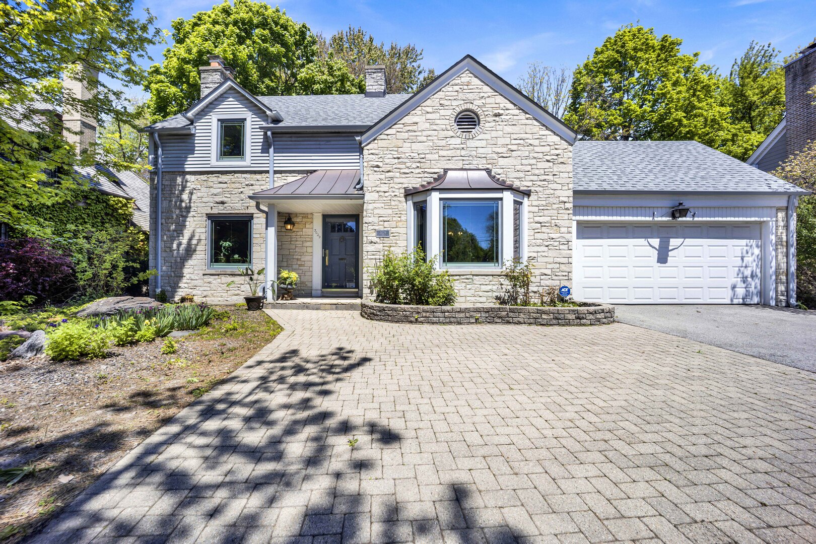 Set on an expansive 70 x 187 lot in a premier Evanston neighborhood, this classic Lannonstone Colonial offers over 2,650 square feet of thoughtfully maintained living space. The home balances timeless architectural character with over $100K in significant infrastructure investments rarely found at this price point.  Light-filled living and dining areas flow seamlessly from the renovated kitchen (2019), which features a marble island, custom cabinetry, and built-in organization designed for everyday living. The enclosed porch offers a peaceful setting for morning coffee while overlooking the deep, park-like backyard.  The versatile floor plan includes a coveted first-floor bedroom and full bath-ideal for guests, a quiet home office, or multigenerational living-while the finished lower level provides a cozy retreat with exposed wood beams and a second brick fireplace.  This turn-key residence has been meticulously updated for long-term peace of mind, including a new roof (2021), new sewer line to the street with backflow preventer (2024), updated copper water supply line and new water heater (2024), and Tesla EV charger installation (2025).  Complete with an attached garage, convenient turnaround driveway, and ample parking for three additional vehicles, the property offers a rare combination of expansive outdoor space and everyday functionality within an established community served by D65 and ETHS.