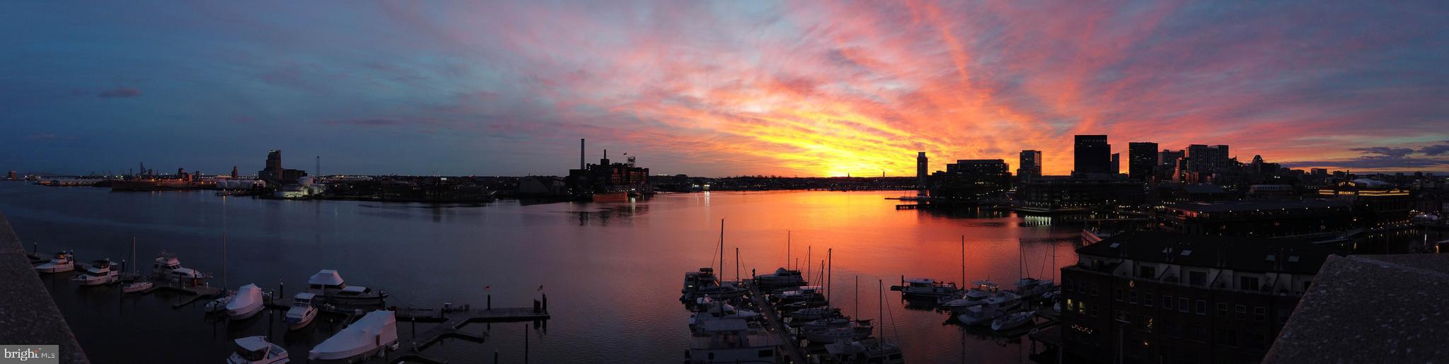 Live authentically. Baltimore’s Hidden Gem. Welcome to the crown jewel of Henderson’s Wharf—a one-of-a-kind top-floor, two story corner penthouse offering breathtaking 270-degree water views from every window. This is the only unit of its kind, perched above the building’s private garage for unmatched privacy with no neighbors above or below. Premium Waterfront Location. Situated on a quiet peninsula. Unparallelled and ever-changing panoramic views. No two sunsets are the same. Revel in the soaring 20-foot ceilings, rarely found. Your 450 sq. ft. of wrap around brick terrace blurs the boundaries of indoor and outdoor living. Inspiring morning yoga... tune into your circadian rhythms. Every room delivers a cinematic view of Baltimore’s skyline and harbor. From Fourth of July fireworks to golden-hour sunsets, it’s like living in a waterfront postcard. Boat lovers, this isn’t just waterfront—it’s dockfront. The building has a private marina attached, so you can walk from your living room to your boat in minutes. Grab your coffee, stroll down, cast off. A boaters dream. Two deeded parking spaces sit directly below the unit with your own EV charger—a rare find. It’s like having your own private garage in a luxury building. Walk up a few steps and you’re home—no elevators, no long hallways, no hassle.Located in the heart of historic Fell’s Point, your community has cobblestone streets that blend charm, culture, and culinary delights. With over 120 pubs and restaurants, you’re never far from your next favorite meal, cocktail, or waterfront stroll. Create the experiences you crave footsteps from your penthouse door. Cultivate your existence. The art of uniting human and home. Legendary former Ravens Ring of Honor Member has spent a long and loving chapter of his life in this penthouse. He and his family has cherished the views, the space, the peace, the connection to nature, big skies, spectacular Fourth of July fireworks, and all that the Fells Point Community has to offer.