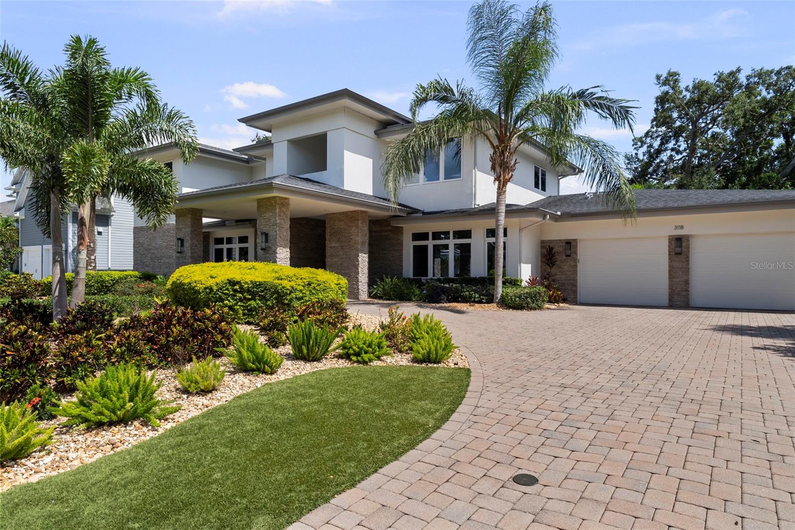As you approach this stunning custom residence by Taralon Homes, a stately porte-cochère and circular brick driveway create a grand first impression, setting the stage for the refined elegance that lies within. Situated on a large, elevated lot with an expansive front lawn featuring manicured artificial turf and lush, tropical landscaping, the home enjoys a commanding presence just moments from Bayshore Boulevard. This contemporary masterpiece offers over 4,700 square feet of thoughtfully designed living space that seamlessly blends modern sophistication with everyday comfort. 
A rare luxury in South Tampa, the oversized 4-car garage offers ample room for guests, a car collection, or additional storage needs.

Inside, every detail reflects quality and intention—from elegant custom lighting and designer fixtures to a floorplan that balances luxurious living with practical functionality. The home features five spacious bedrooms, three and a half bathrooms, a private study, an entertainment loft, a flexible multi-purpose room perfect for a gym, nursery, or second office, and generous storage throughout. Gently lived in, the home remains in pristine, like-new condition.


At the heart of the home is the spectacular chef’s kitchen, outfitted with sleek European-style cabinetry, quartz countertops, and high-end JennAir gas appliances. Three oversized islands serve distinct purposes—preparation, serving, and socializing—making this space ideal for entertaining and everyday living. Soaring ceilings with designer custom detailing and recessed lighting enhance the expansive open-concept layout.

Indoor-outdoor living is elevated by a dramatic 90-degree sliding glass wall that opens to a breathtaking two-story screened lanai. This private outdoor retreat features The outdoor living area includes a plunge pool with spa functionality, offering both a place to refresh during the day and a heated spa experience in the evenings, a dual-sided fireplace, built-in gas firepit, and an outdoor kitchen, all set among travertine pavers, manicured artificial turf, and full privacy fencing.

Modern technology and peace of mind are seamlessly integrated throughout the home. A whole-house Control4 system manages smart home functions, including the thermostat control, with all equipment discreetly housed in its own dedicated room. Additional features include a security system with cameras and a whole-house natural gas generator for enhanced safety and convenience.

Located in Flood Zone X—no flood insurance required.

This is more than a home—it’s a curated lifestyle in one of South Tampa’s most desirable neighborhoods.