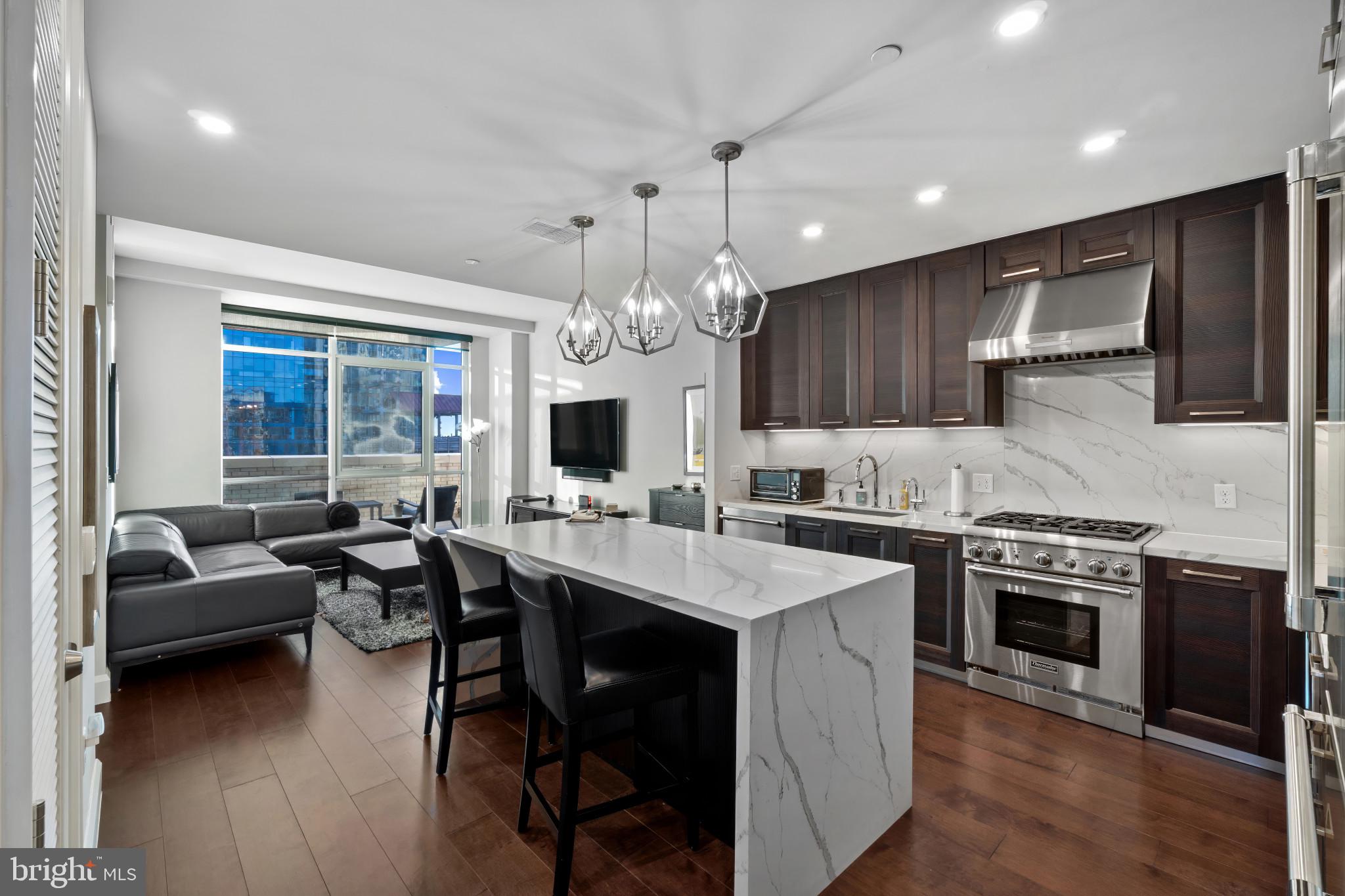 Welcome to luxury living at the Liberty Harbor East, one of Baltimore’s premier waterfront addresses. This spacious 1-bedroom 1-bath residence on the 6th floor offers 900 square feet of beautifully designed living space with 9-foot ceilings, wide-plank hardwood floors, and floor-to-ceiling windows showcasing the city’s harbor views. The open kitchen features custom Italkraft cabinetry, Thermador appliances, a gas range with vented hood, and a striking marble waterfall island that flows into the living area - perfect for both relaxing and entertaining. The primary suite includes a walk-in closet and spa-like bathroom finished in Carrara marble with an oversized shower and dual vanity. Enjoy the private balcony for morning coffee or a peaceful evening taking in the harbor views. The Liberty is a boutique luxury condominium with just 33 residences, located directly above a flagship Whole Foods Market and surrounded by a wonderful variety of restaurants and shops. Residents will also enjoy access to over 30,000 square feet of private, state-of-the-art indoor and outdoor amenity spaces including a clubroom with indoor/outdoor bar, rooftop infinity pool deck with cabanas, courtyard seating, grilling stations, communal and private dining rooms with catering kitchen, fitness center, yoga studio, pet park, conference rooms, and study lounge with computer stations and fireplace. This superb location gives easy access to all areas of the city as well as 95/295 /895 for a smooth commute. This property includes a parking space in the attached garage.