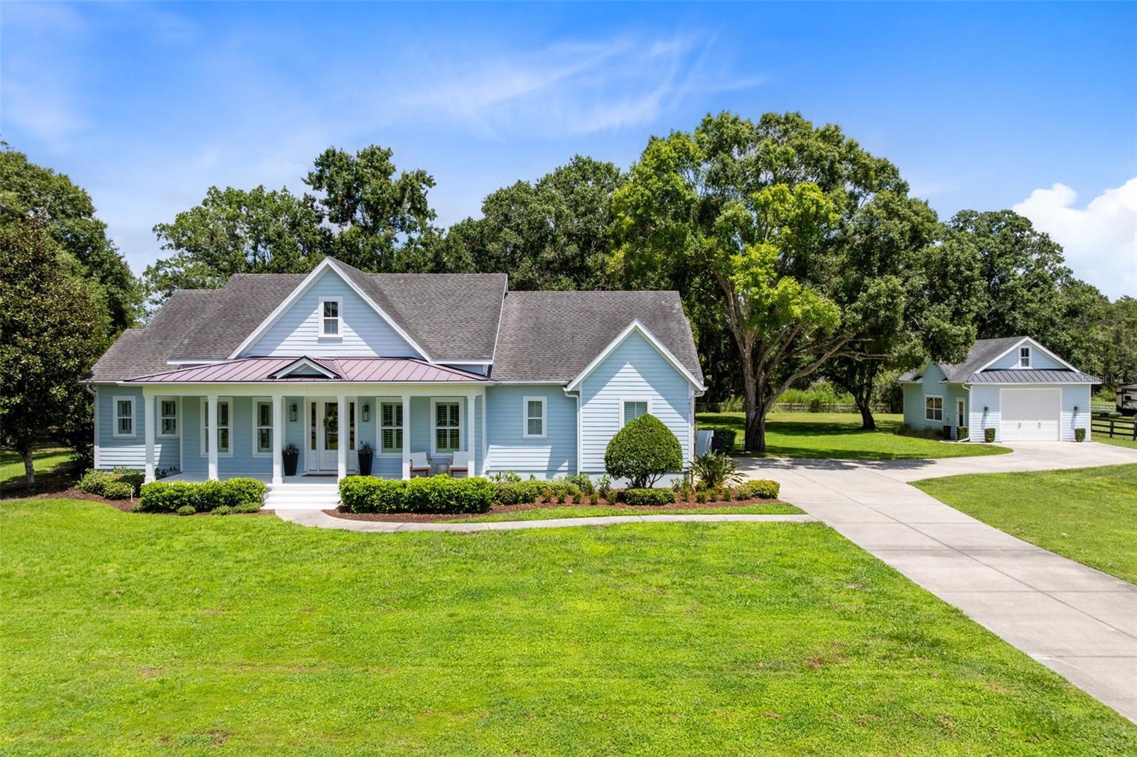 Welcome to this absolutely breathtaking, one-of-a-kind home perfectly poised on arguably one of the most beautiful lots in Saint Cloud's most desirable neighborhood. No detail was left out of the design process for this original coastal farmhouse. From brick wall accents to the hidden pantry and staircase,  to simply the well thought-out design that embraces practical style and functionality, this home exudes an elevated and comfortable lifestyle. Downstairs and on one side of the home, the Primary Suite, complete with spacious ensuite bath and massive walk-in closet, showcases picture windows allowing for natural light to filter in, and French doors leading to the back porch and yard. Also downstairs, 2 other bedrooms with jack-and-jill bathrooms allow for children or guests to have their own privacy and space. One of the most unique and show-stopping features of the home is the well-appointed office just off the foyer. This glass-front room provides not only a functional, but a beautiful place to work. Equally impressive is the living room with built-ins and an electric fireplace, all  overlooking the pristine, private back yard, and also visible from the gourmet kitchen and dining area. You won't be at a loss for storage-or style-here. Up the hidden staircase, a loft with separate bonus room allow for a 4th bedroom and playroom, den, or homeschool room. You'll also have easy access to the impressive attic storage as well. Outside, the front and back porches allow you to take in the gorgeous outdoors. The back porch is screened and a perfect place for entertainment with speaker system and surround sound there, and throughout the interior as well. Attached to the home is a very clean 3-car garage. If that's not enough, the detached bonus garage provides ample storage as well. Currently used as a home gym, the sky is really the limit for this space. For a better tour of what this estate has to offer, view the property video and 3D tour, or schedule a private viewing today!