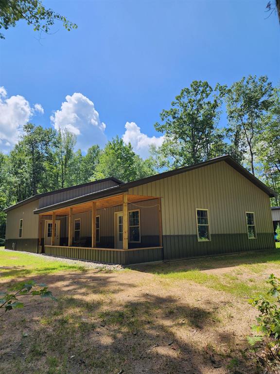 A great Barndominium located on 10 wooded acres in the country on a secluded, peaceful, quiet, private dead-end road, yet only 5 miles from Walmart. Radiant floor heat in house AND the attached 30 X 36 garage! Room for your tools & workshop, cars, tractor, side by sides, snowmobiles, etc.!!! Plus there is a portable carport on the property. Home & garage have spray foam insulation, R-38 in garage & more in the house. Nice outdoor wood burner & shed full of wood for your use. Low utility bills too! A 15KW generator & can easily add Solar to it. Large open floor plan with Amish tongue & groove ceiling & a great barn bathroom door. The bath has a spacious tile shower & the laundry room is located in the bathroom. There's a 6' X 30' covered front porch overlooking fire pit, flagpole & woods. The property is mostly wooded with many trails for walking/riding & assessable to State land trails. There's even a circle driveway! Great hunting with deer on the property & lots of other wildlife. Property has been split into two 5 acre parcels, survey on file. Car hoist is not included with the sale.