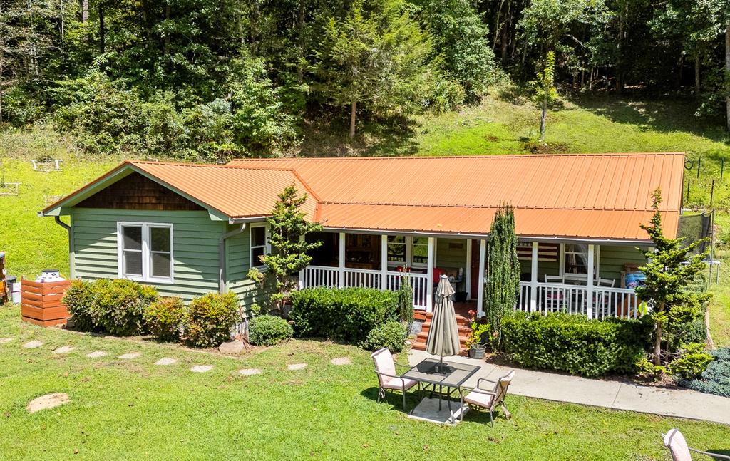 Set on over two unrestricted acres, this PARTIALLY FURNISHED single-level home offers an ideal blend of modern comfort and rural charm. Conveniently located on a paved road with a short gravel driveway, the property is thoughtfully landscaped with mature evergreens, flowering shrubs, and expansive open spaces that enhance its peaceful setting. Fully remodeled in 2016, the home features a durable metal roof installed in 2021 and an inviting covered front porch that creates a warm first impression. Step inside to the living room, with rich wood flooring, built-in bookshelves, and a cozy gas-log fireplace. The adjoining dining area flows seamlessly from the living space, providing a versatile layout well suited for both everyday living and entertaining. The bright, well-appointed kitchen is the heart of the home, with a pretty bay window over the sink, generous cabinet and counter space, a pantry, and a skylight to bring the outdoors in. Just off the kitchen is a spacious laundry room with a convenient utility sink and a door leading out to the backyard. Down the hall, two comfortable bedrooms and a flexible bonus room offer adaptable living options, each enhanced with electric fireplaces for year-round comfort. The full bathroom features a dual sink vanity, providing ample cabinet and counter space. Outdoors, a detached double carport offers covered parking, while the expansive grounds present endless opportunities for gardening, recreation, or simply enjoying the tranquil surroundings. Fiber Optic internet ensures fast, reliable connectivity for remote work and entertainment. With the serenity of country living in a picturesque setting, this property will be a peaceful place for you to call home.