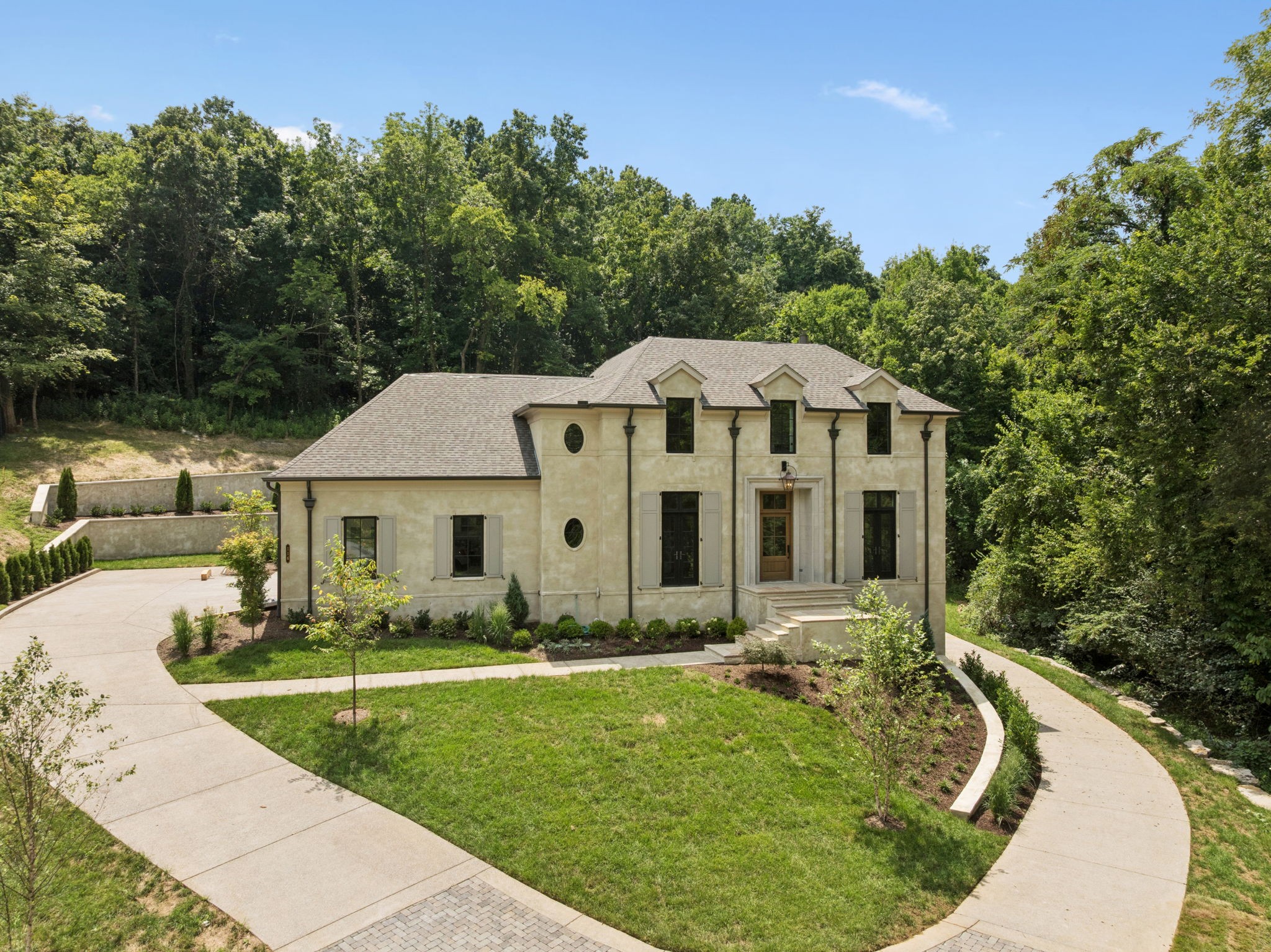 Nestled within the prestigious gated community of Avalon, this stunning, custom new construction home combines timeless design with modern functionality. No detail was missed in the planning of this home. Featuring a primary suite and an additional guest suite on the main level, two spacious, en-suite bedrooms upstairs, and a fully private in-law quarters downstairs. The in-law quarters is complete with its own kitchen, living room, laundry room, separate entrance, and oversized garage—ideal for extended family, guests, or nanny quarters. There is additional heated and cooled storage downstairs and the home is equipped for an elevator if you want to put one in. With entertainment in mind, the outdoor living space showcases a custom outdoor kitchen, beautifully landscaped grounds, and mature trees bordering 2 sides of the property for privacy. There is also room for a pool. This home is nestled in a quiet, gated community, yet a quick drive to I-65, Cool Springs, historic Franklin, and downtown Nashville. The convenience to all Franklin's amenities while maintaining luxury and privacy are unparalleled. This is a rare opportunity to enjoy luxury, privacy, and convenience in one of Franklin’s most sought-after communities.