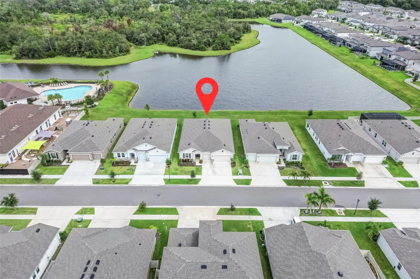 Under contract-accepting backup offers. Price Improvement – Exceptional Pond & Conservation Views, Now $549,000! One of the Best Pond & Conservation Views in the Community! Where modern comfort meets family living on one of the most desirable POND and CONSERVATION lots in the community, this spacious 4 bedroom, 3.5-bathroom home with a 3-car garage has been lovingly maintained and upgraded so the next family can move right in without lifting a finger. Inside, the inviting open-concept layout showcases a large kitchen island with seating, stone countertops, stainless steel appliances, and convenient pull-out shelving in the cabinets, all flowing into the breakfast nook where you can enjoy morning coffee with peaceful WATER VIEWS. The SEPARATE IN-LAW SUITE offers its own living room, kitchenette with fridge and sink, full bathroom with walk-in shower, and private bedroom ideal for MULTIGENERATIONAL LIVING, visiting family, or even a private office retreat. Walk-in closets have been thoughtfully customized with shelving to maximize storage, while new ceiling fans with remotes, faux wood blinds, smart lighting, and upgraded hardware throughout add both comfort and style. Imagine family dinners in the oversized dining room with elegant tray ceiling detail, or cozy evenings in the living room where sliding glass doors open to a COVERED PATIO overlooking the pond and conservation area (FENCES ALLOWED) creating the perfect backdrop for entertaining or simply relaxing at home. The spacious owner’s suite offers another tray ceiling, a spa-like bathroom with dual vanities, garden tub, walk-in shower, and a generous walk-in closet. Even the practical spaces have been UPGRADED, from the laundry room with its added UTILITY SINK and CABINETRY to the garage with EPOXY COATED FLOORING, ceiling-mounted HEAVY-DUTY STORAGE RACKS, and shelving to keep everything organized. And when it’s time for fun, the community AMENITIES are just steps away - only a 30-second walk to the resort-style pool, playground, pickleball and tennis courts, all set against the same beautiful pond and conservation views. Families will also love having O2B Kids nearby, a nationally accredited early learning center offering preschool, after school care, and summer camp programs. With its prime location, extensive upgrades, and MOVE-IN READY CONDITION, this home is the perfect place to create lasting memories for years to come.