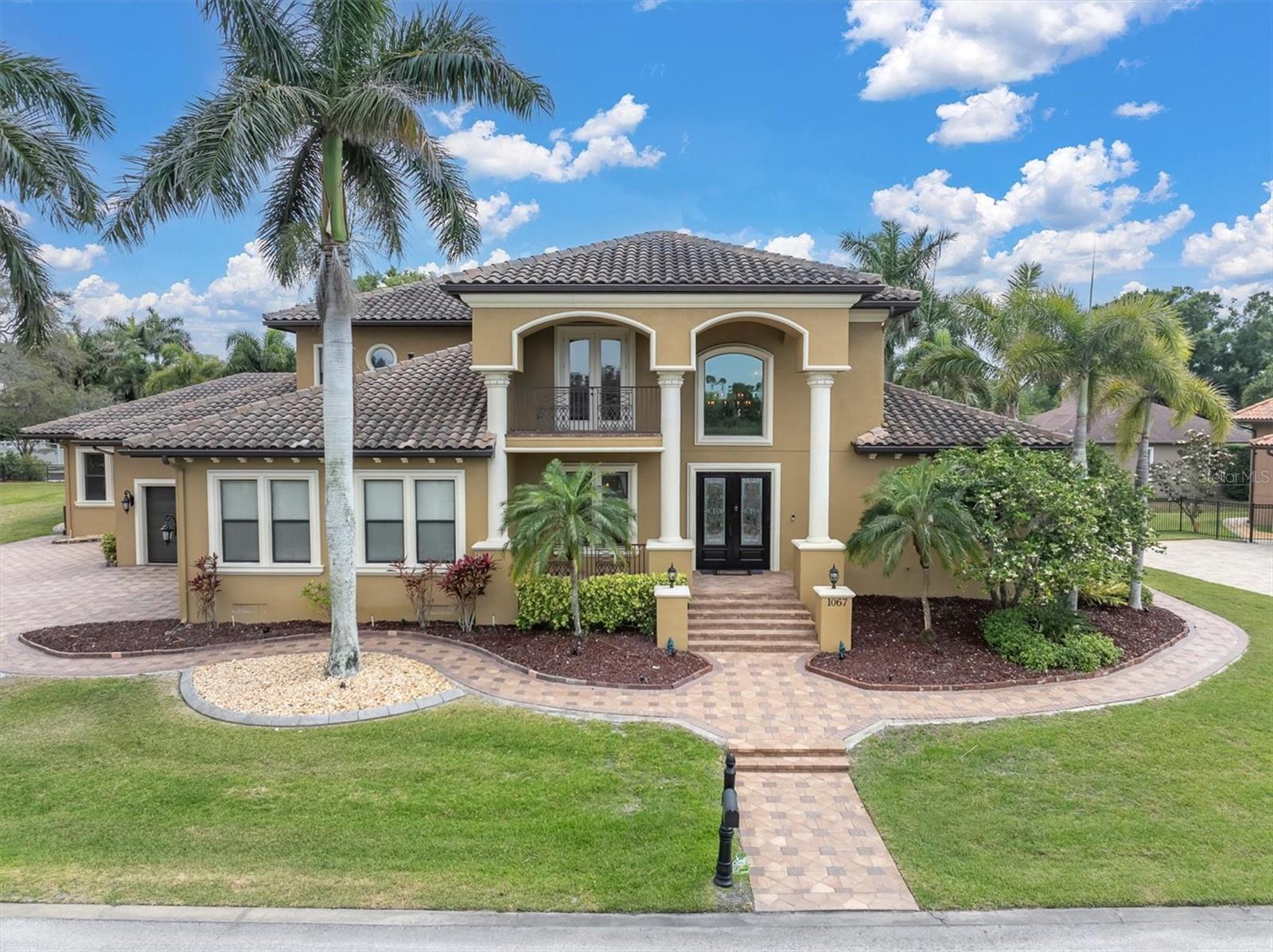 Welcome to 1067 Ashland Ave, a sophisticated Tarpon Springs residence offering over 5,800 square feet of refined living just minutes from Sunset Beach. Designed for both elegance and resilience, this custom home features 4 bedrooms, 6 bathrooms, a 3-car garage, dual lanais, a resort-style pool, Wolf/Sub-Zero kitchen, Tesla backup power, solar panels and a private in-law suite with its own entrance.The heart of the home is the chef’s kitchen, equipped with Wolf appliances, Sub-Zero refrigeration, custom cabinetry, and an oversized island that flows seamlessly into expansive living and dining spaces. Natural light fills the interior through large windows and sliders, creating a warm, inviting atmosphere.The primary suite is a private retreat with generous proportions, a spa-inspired bathroom, and custom storage. Three hurricane-rated safe rooms provide peace of mind, while dual Tesla Powerwall backups ensure uninterrupted comfort during storms.Outdoor living is elevated with two separate lanais—one featuring a fireplace and retractable screens—overlooking a custom pool designed for relaxation and entertaining. Whether hosting gatherings or enjoying quiet evenings, these spaces offer year-round enjoyment.A rare highlight is the in-law suite, complete with a private entrance, full bath, and living area—ideal for multigenerational living, guests, or extended stays.Located in one of Tarpon Springs’ most desirable pockets, this home offers quick access to Sunset Beach, Fred Howard Park, the Sponge Docks, and the vibrant local dining scene. Luxury, comfort, and coastal living come together seamlessly at 1067 Ashland Ave.Shown by appointment.
