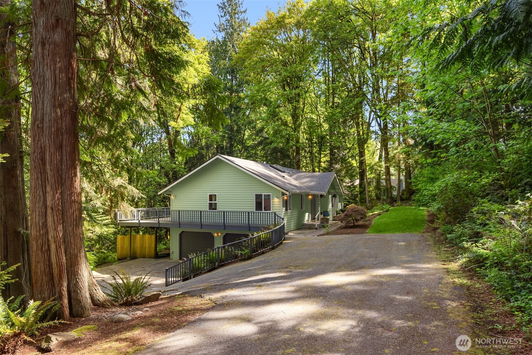 Tucked into a scenic Pacific Northwest setting adjacent to Edgewater Estates, this private home overlooks 8 acres of tranquil woodland beauty. The thoughtful floor plan offers the ease of main-level living with the added versatility of a separate lower-level living space. High ceilings and abundant windows create a light-filled atmosphere throughout the main floor, featuring a spacious kitchen, dining area, den/office, guest bedroom, and primary suite. Step onto the expansive deck from both the dining area and primary suite to enjoy the peaceful views and sounds of nature year-round. Downstairs, the private entrance opens to a flexible living area complete with kitchenette, living room, bedroom, bath, and bonus room—ideal for guests, multi-generational living, or creative use. Oversized 3-car tandem garage with shop/storage space. Minutes to Poulsbo, ferries, Bangor, and Silverdale. Don't miss the community beach access and the park.