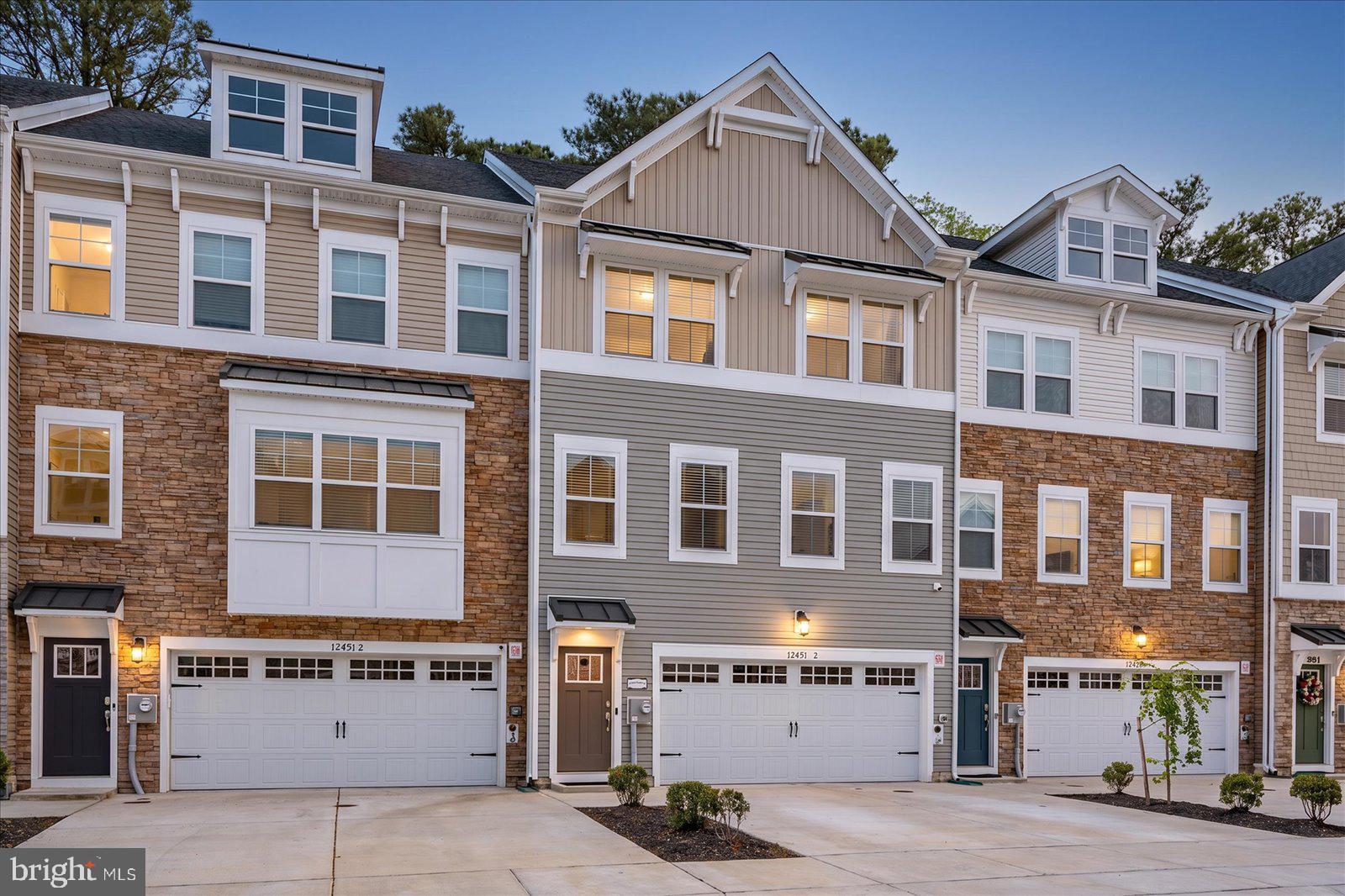 Welcome to Sea Oaks Village — a beautifully designed 2023-built coastal townhome backing directly to a serene wooded buffer for added privacy and tree-lined views. Offering four levels of light-filled living just minutes from the beach, the bay, and everything the Eastern Shore has to offer, this 4-bedroom, 3.5-bath home blends modern construction with a layout built for both quiet mornings and lively gatherings.Enter through the welcoming front foyer and arrive at a convenient mid-level landing where you can head up to the main living level or down to the ground-floor flex room. That first-floor space features a full bath and a private walkout to the hardscaped rear patio that opens to the tree line — perfect as a home office, media room, gym, guest suite, or fourth-bedroom alternative. The ground level also includes a dedicated laundry/mudroom with direct access from the oversized garage, making everyday in-and-out a breeze.The main living level is the heart of the home, showcasing an open-concept great room, dining area, and a true chef's kitchen featuring the upgraded package: double wall ovens, stainless appliances, an oversized quartz island with seating for the whole crew, designer cabinetry, and a sun-drenched morning room that opens to an expansive open-air deck — ideal for grilling, sunset dinners, and unwinding around the fire pit while overlooking the woods.The third level features three generously sized bedrooms, including a serene primary suite with a spa-style en-suite bath (oversized tiled shower, dual vanity, and walk-in closet) plus two additional bedrooms served by a full hall bath. Head up to the fourth-floor loft retreat — a versatile bonus suite with its own private walkout balcony perched at treetop level — easily used as a fourth bedroom, second primary, teen suite, or rec room.Built in 2023 with all the modern systems, energy-efficient features, and warranty-era peace of mind that come with newer construction, this home lives larger than the square footage suggests, with the wooded rear setting delivering a true sense of escape. Sea Oaks Village offers resort-style amenities including an outdoor pool and clubhouse, sport court, playground, fishing pier, and tranquil ponds and walking paths winding through the neighborhood. A short drive lands you at the white-sand beaches and boardwalk of Ocean City, the wild ponies and protected dunes of Assateague Island National Seashore, and the charming shops, galleries, and award-winning dining of historic downtown Berlin — repeatedly named one of America's Coolest Small Towns. Local favorites like Sunset Grille, Hooper's, On The Bay Bistro, Fager's Island, and the Shark on the Harbor are just minutes away, along with Tanger Outlets, Eagle's Landing Golf Course, and the West OC marinas.