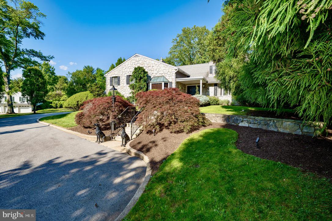 Welcome to 405 Boxwood Road, an exceptional and distinctive residence set at the end of a long, private drive on two beautifully manicured acres in the sought-after Beaupre section of Radnor Township. Offered for the first time since its original development, this remarkable property combines an uncommon sense of privacy with expansive views, thoughtfully designed living spaces, and an extraordinary array of amenities for both everyday living and entertaining.From the moment you arrive, the care and intentionality behind the design of both the residence and its grounds are immediately apparent. Spanning five levels, the home offers an impressive balance of formal and informal spaces, with generously proportioned rooms designed to accommodate everything from quiet living to large gatherings of family and friends.The main level welcomes you through a gracious foyer and features formal living and dining rooms, along with a chef’s kitchen that opens seamlessly to a breakfast nook and sunroom. The adjacent family room is an inviting gathering space and includes a custom bar complete with refrigeration, and sink. Also on this level is a versatile bonus room, beautifully appointed with custom woodwork and a gas fireplace, ideal for use as a private office, library, or den.The lower levels transform the home into an exceptional destination for entertainment. A spectacular custom bar, crafted from a reclaimed bowling alley, anchors the expansive entertaining room, while additional spaces include a game room, den, wine vault, and a second kitchen - particularly well suited to catered events and larger gatherings.The private primary suite is conveniently located just steps from the family room and offers a spacious bedroom with gas fireplace, a full dressing room that could readily serve as an additional bedroom, two walk-in closets, and a custom-designed bath featuring a stall shower, dedicated makeup area, and jetted tub. This level also includes a second bedroom suite with its own full bath, a loft, and hidden access to a versatile lower-level space.The uppermost level provides two additional generously sized bedrooms, a full bath, and a spacious sitting area, offering flexibility for family, guests, or additional private living space.Outside, the property takes full advantage of its extraordinary setting. A large stamped-concrete terrace provides an ideal setting for outdoor dining and entertaining, overlooking the in-ground swimming pool and outdoor kitchen. Mature trees, beautifully planted gardens, ponds, and meticulously maintained lawns create a private and tranquil landscape that feels remarkably removed from the everyday.An attached garage and detached garage provide parking for four vehicles, while the expansive grounds offer ample opportunity to further customize the property to suit your lifestyle.Currently presented in move-in condition, 405 Boxwood Road offers a rare opportunity to acquire a substantial and highly private residence in one of Radnor Township�����s most desirable settings, with the space, character, and versatility to make it truly your own.