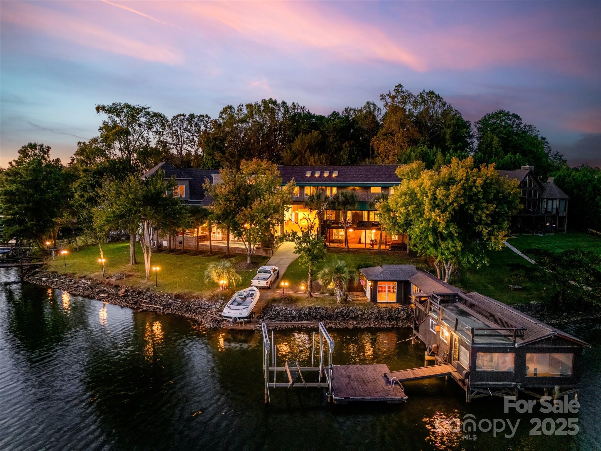 Unique custom-built waterfront home on Lake Wylie. Perfect for a large family or anyone who loves to entertain! Beautiful lakes views throughout the entire home. Enjoy your (2) private docks, one with a boat lift, your own private boat ramp to launch into the lake and enjoy anytime. The boathouse has plenty of room with its own kitchen for those fun days out on the lake. The main home provides an open great room with fireplace, full gourmet kitchen, commercial grade stainless appliances and hibachi stove top, wet bar, and walk-in butler's pantry all leading to the large Trek deck overlooking the lake. The large open-airy primary bedroom provides amazing natural light from the skylights to the balcony overlooking the lake, dual walk-in closets, fireplace and your private sitting room and wet bar area. The walk-out finished basement with separate bedroom and full bathroom leads out to a private brick patio overlooking the lake.  The separate living quarter/apartment area attached to main home includes a private entrance, large living area, bedroom, bathroom and full kitchen perfect for guests or an in-law suite. The extended wing that is also connected to the main home also with a separate entrance has a beautiful custom library/office with fireplace that overlooks another great room with beautiful lake views. The wing also has a beautiful full kitchen, separate bathroom w/sauna that leads to the Gunite pool/outdoor kitchen and fireplace. The gathering/lounge room leads to a private theater room perfect for cold/rainy days. There are several garages, one connected to the main home with built-in cabinets can easily fit several cars and/or toys. The large, attached garage(s) to the wing has an area large enough to pull your RV/Camper or boat, that is wired for 50 AMP and has plenty of room several vehicles, hobbies and work.