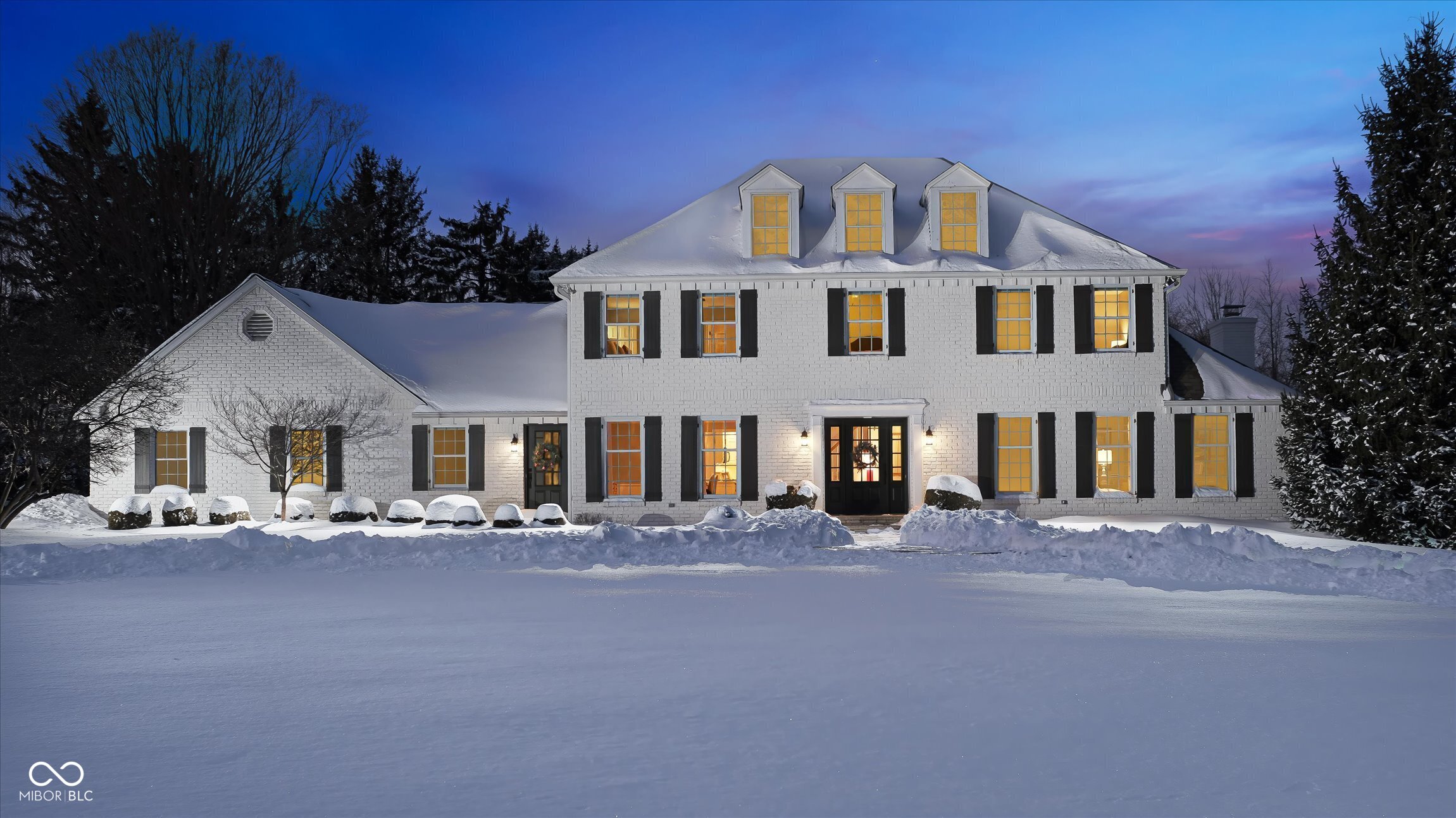 4930 Wintergreen Lane - Woodbrook Downs Estates. Rare, private 1.5 acre retreat just minutes from downtown Carmel. Sited behind the property is a one acre meadow and buffered by 25 acres of woods, this distinctive 3,600 square foot home offers 4 bedrooms, an office, a finished, soundproofed basement, and a 3 bay garage - plus an outbuilding formerly used as a small stable.  Light-filled living is at the heart of the home: a 2014 family room addition converted the former screened porch into a four season sitting room with HVAC and three all windowed exterior walls framing views of the 20,000 gallon heated in-ground pool and wooded yard. The expansive paver pool deck provides roughly 2,500 sq ft of outdoor entertaining space. Interior highlights include uniform natural wood flooring on the main level, updated quartz countertops and resurfaced kitchen cabinets, and a remodeled upstairs bath.  The lower level is a standout - a professionally constructed, soundproofed music studio with double 5/8" drywall, acoustic underlay and custom panels that also makes an ideal home theater or gaming room. The basement also offers abundant storage. Practical systems have been well maintained or replaced: roof and gutters (2017), HVAC (2013), driveway resurfaced (2019), water systems (2019), sewage lift station (2024), pool gas heater (2023) and a new sump pump (2025).  A special property for buyers seeking privacy, generous indoor/outdoor living and unique amenities - including the versatile outbuilding and easy access to downtown Carmel.