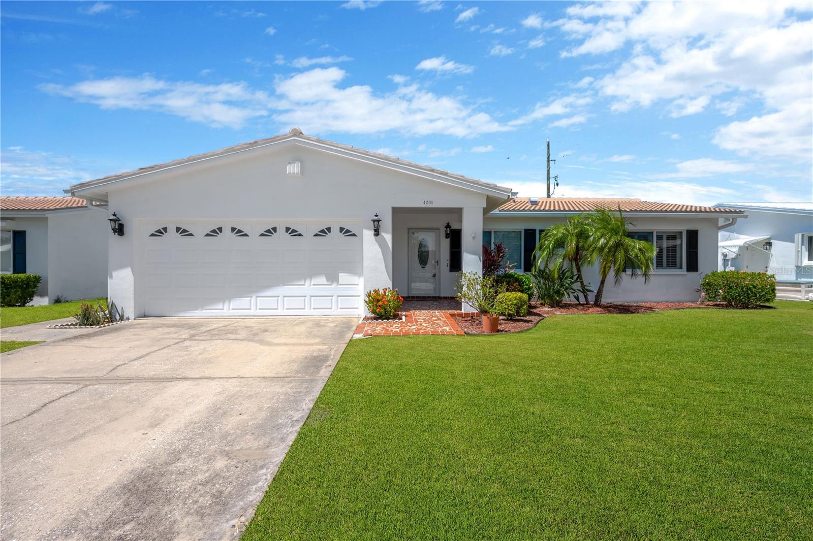 Welcome home to the Mainlands of Tamarac! This tastefully updated home is situated on the 18th fairway of Mainlands Golf Course, offering beautiful green views and a spacious interior.As you arrive to your new home, you are greeted by attractive landscaping, a two-car garage, and a thoughtfully designed two-bedroom, two-bathroom floor plan with plenty of space and dual living areas. The pass-through kitchen offers both functionality and connection to both living spaces, while the full-size laundry room adds everyday convenience. Off the kitchen, a bonus room provides the perfect space for a home office, hobby room, or flex space. Sliding glass doors off the family room lead to a covered patio and backyard area, creating an ideal setting for relaxing or entertaining. Abundant natural light fills the spacious interior, adding to the home’s warm and comfortable feel.Recent updates include luxury vinyl flooring throughout the kitchen and living areas, a tastefully renovated kitchen, newer windows, recessed lighting, a new roof with gutters and downspouts installed in 2023, and recently installed carpet in both bedrooms.  Both bathrooms in the home have been updated and provide plenty of vanity storage.  The primary bedroom features an ensuite bathroom with a step-in jetted tub. Mainlands of Tamarac is a 55+ community that offers it all. Amenities include social events, a swimming pool, and maintenance-free living with easy access to the public golf course. Association dues cover lawn care, common areas, water, sewer, trash, cable, internet, and more.Pet-friendly community — two pets allowed, up to 35 pounds each. Restrictions apply.Golf cart-friendly community.