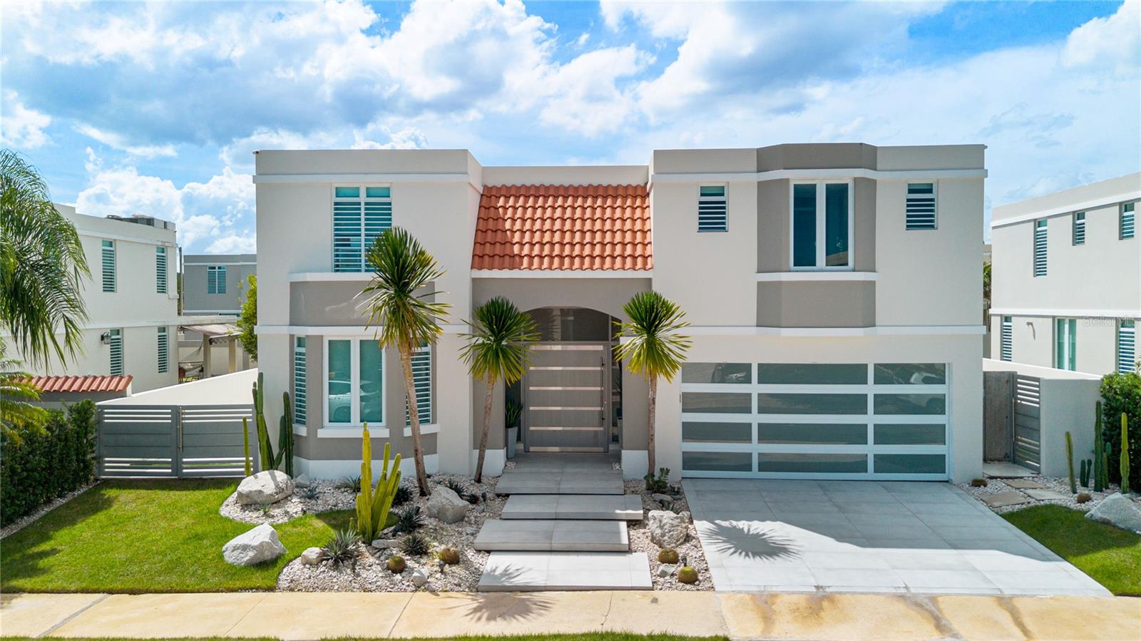 This beautifully upgraded two-story residence offers modern interiors, elegant finishes, and exceptional outdoor living spaces, ideal for both everyday comfort and entertaining.The home features bright, spacious living and dining areas, a family room, a well-appointed kitchen, a dedicated home office, and a generous primary suite. Additional highlights include custom built-in cabinetry, decorative ceiling details, recessed lighting, and a modern staircase with glass railings.The impressive outdoor area is designed for relaxation and entertainment, featuring a stunning swimming pool with a hot tub, waterfall feature, and built-in lounge chairs. A spacious porcelain-tiled covered terrace includes outdoor dining and seating areas, a TV lounge, a fully equipped BBQ and bar area, and stylish pergolas. A sunken seating area with a fire pit, a separate multipurpose structure, an outdoor bathroom, and beautifully landscaped gardens complete this private retreat.Additional features include a balcony off the primary bedroom, an upgraded front entrance and exterior façade, custom ceiling fascias, furnishings and appliances, a 15 kW Kubota generator with automatic transfer switch, a stainless steel solar water heater, and a solar energy system with 35 panels and a Tesla battery, subject to a fixed monthly payment of $357.Located in the desirable gated community of Paseo Los Corales II in Dorado, this exceptional property combines contemporary design, comfort, and resort-style outdoor living.