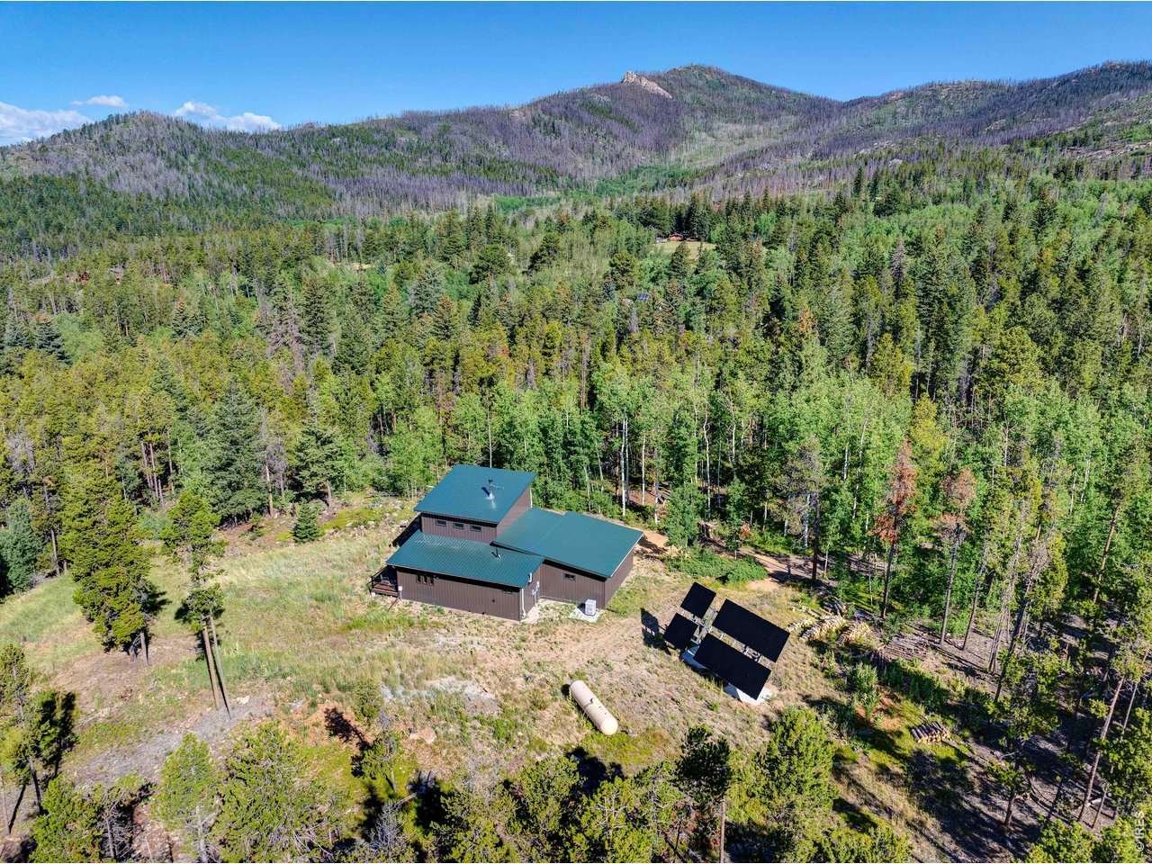 Built in 2022, this modern off-grid cabin offers the perfect combination of contemporary comfort and mountain self-sufficiency on over 5 private acres in desirable Storm Mountain. Designed for year-round living or weekend escapes, the home features owned solar power, a high-producing well, full septic system, Starlink high-speed internet, and a backup propane generator, providing all the conveniences of home while enjoying true energy independence.The cabin showcases authentic Colorado character with beautiful interior wood and rock accents sourced directly from the property, creating a one-of-a-kind connection between the home and its natural surroundings. A cozy wood-burning stove serves as the heart of the living space and even includes a built-in pizza oven, adding warmth, charm, and a fun way to entertain family and friends.Take in beautiful views of Longs Peak while surrounded by towering Ponderosa pines, Douglas fir, blue spruce, golden aspens, impressive rock outcroppings, colorful wildflowers, and abundant wildlife. The property offers exceptional privacy with usable land to enjoy.Just a short walk to Roosevelt National Forest, you'll have direct access to hiking, ATV and OHV trails, hunting, fishing, wildlife viewing, and endless outdoor recreation. Conveniently located between Estes Park and Loveland, this rare Colorado mountain property is ideal as a full-time residence, vacation home, recreational getaway, investment property, or off-grid retreat. Enjoy modern construction, stunning Longs Peak views, energy independence, handcrafted natural finishes, exceptional privacy, and unmatched access to Northern Colorado's mountain lifestyle.