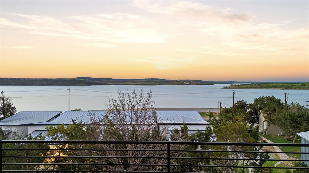 Experience elevated lake living in this stunning new construction overlooking the iconic waters of Possum Kingdom Lake. Perfectly positioned on the peninsula, this property offers sweeping, unobstructed views and unbeatable convenience with direct access to local dining, shopping, and entertainment.Designed with both relaxation and investment potential in mind, this 3-bedroom, 2.5-bath home features a modern, open-concept layout ideal for hosting and entertaining. Expansive windows invite in natural light while showcasing the breathtaking lake views from the main living spaces.Enjoy resort-style amenities including a pool overlooking the lake, perfect for unwinding after a day on the water. With a boat ramp just across the street, lake access is effortless, making every day feel like a vacation.Short-term rental friendly, this property presents an exceptional opportunity for both personal enjoyment and income potential. Whether you're searching for a weekend retreat or a high-performing investment, this is lake living at its finest.