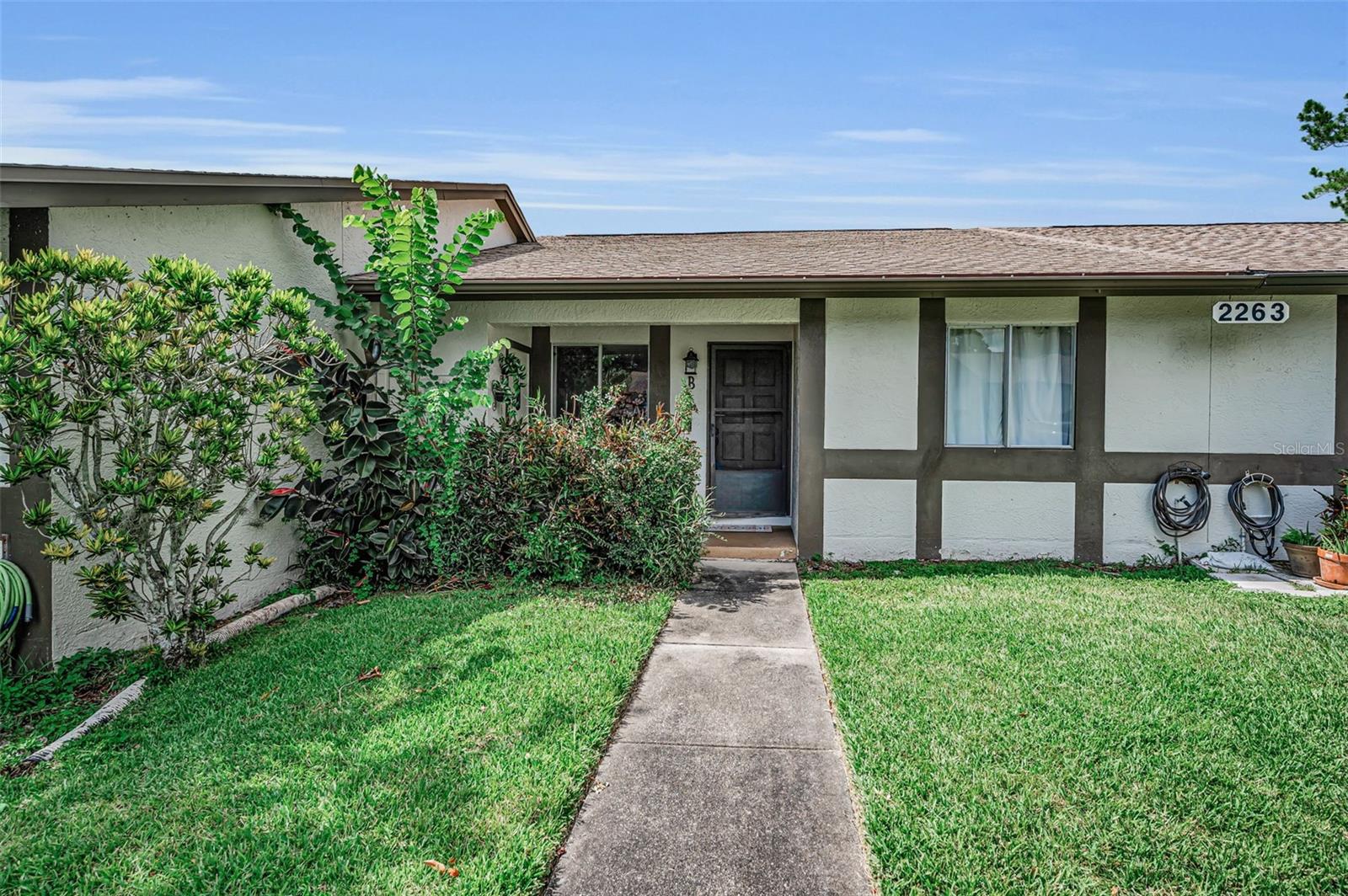 Move-in ready, low-maintenance living in the heart of Palm Harbor! This spacious 2-bedroom, 2-bath villa offers the comfort, updates, location, and easy lifestyle you are looking for. Step inside to find fresh interior paint and updated porcelain wood-look tile flooring flowing throughout the entire home, creating a clean, seamless modern feel from the moment you walk in. The kitchen features a convenient breakfast bar, abundant cabinet storage, and updated appliances approximately 5 years old, making everyday living and entertaining effortless. The split floor plan offers privacy for everyone, with a generous primary suite featuring a walk-in closet and en suite bath, while the second bedroom is privately situated with easy access to the other bathroom — ideal for guests, a home office, or additional living space. Enjoy your morning coffee or unwind at the end of the day in the enclosed Florida room, complete with new windows and a new exterior door. This is where you have your laundry closet which includes the washer and dryer. Step out back where you have pavers and a clean slate to add your touches for an outdoor space. Located in Palm Harbor and zoned for A-rated schools, this villa also puts you less than a 20-minute drive from Honeymoon Island and close to the best of downtown Palm Harbor and downtown Dunedin, where you’ll find shopping, restaurants, entertainment, events, and so much more. With a 2020 roof, 2019 AC, community pool, clubhouse, and an HOA of only $166/month covering trash, sewer, cable TV, internet, pool, and clubhouse - this home delivers comfort, convenience, and serious value. Schedule your showing today — homes with this much to offer in this location don’t last!