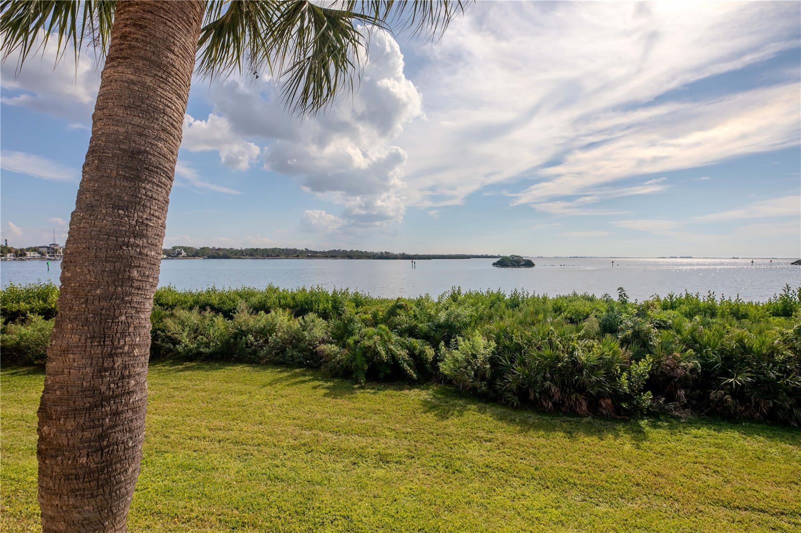 Experience Gulf-front living in this well-cared-for first-floor residence in Tarpon Cove, a private, 24/7 guard-gated waterfront community on Klosterman Point overlooking the Gulf of Mexico. This home offers full Gulf views, the privacy of protected mangroves, and the rare convenience of no stairs with elevated, storm-smart construction.The interior has been gently used by a seasonal owner and offers a clean canvas for updates to match a buyer’s style. Recent improvements include fresh paint in the kitchen, primary suite, bathroom and new shelving. System dates include a Rheem HVAC (2002) and water heater (2014). The kitchen, dining room, living area, primary bedroom, and balcony all capture full Gulf views. Impact-rated sliders protect the balcony and allow year-round enjoyment of the coastal setting. Tarpon Cove provides direct Gulf access through its private marina, with boat slips available for rent (currently $450/quarter). Under-building storage is ideal for kayaks or paddleboards. The community offers two heated pools, a spa, a fitness center, tennis courts, a clubhouse, and a peaceful waterfront nature trail. With maintenance-free living and secure gated access, this property is ideal for seasonal or full-time owners seeking comfort, privacy, and Gulf-front living minutes from barrier islands, beaches, and the best of Tarpon Springs.