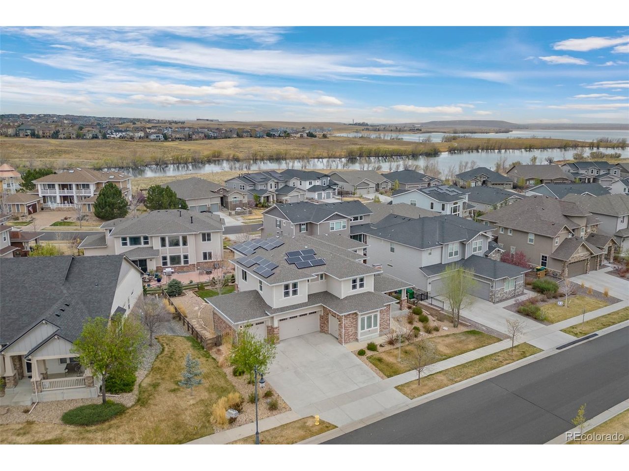 SELLERS ARE OFFERING A $15,000 BUYER CASH CONCESSION FOR CLOSING COSTS OR TO BUY DOWN INTEREST RATE. A rare combination in Southshore: reservoir-community living paired with mountain and lake views from a private primary balcony. This 5-bedroom, 5-bathroom residence pairs a chef's kitchen - oversized island, gas range, pot filler, and butler's pantry - with rich hardwood floors, a main-floor office built for hybrid work, and a striking piano room wrapped by a dramatic circular staircase.Upstairs, the primary suite delivers on the view with a private balcony framing the mountains and lake, plus a spa-style bath with separate vanities, a soaking tub, a double shower, and a walk-in closet with direct access to the upstairs laundry. Three additional bedrooms round out the level - two sharing a Jack-and-Jill bath, one with a private ensuite.Outdoor living is layered across three distinct spaces: a covered front porch, a mid-house patio with an outdoor fireplace, and a covered back deck overlooking a water-wise turf yard built for year-round use with minimal upkeep.The finished basement adds a fourth bedroom, a full bathroom, a spacious great room, and a kitchenette - flexible enough for guests, a long-term visitor, or multi-generational living.The four-car garage brings serious room for vehicles, storage, and a workshop setup wired with supplemental power - built for car enthusiasts and hands-on hobbyists alike.As a Southshore resident, you'll have access to the community's Boathouse - outdoor pools, a fitness center, clubhouse, playground, fishing pond, and trail access straight to Aurora Reservoir. Combined with the space, the views, and the workshop-ready garage, this is a home built for how people actually live now.