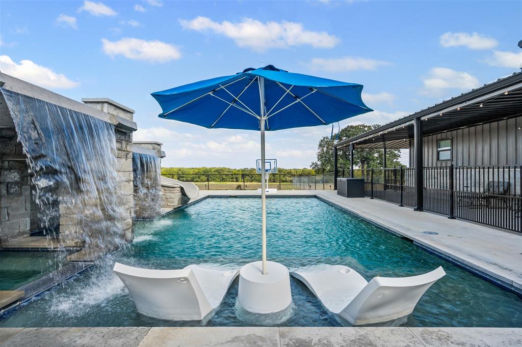 Experience the ultimate Texas lifestyle at 9700 Nix Road. A rare ag exempt, 40+ acre estate in Tolar offering two homes, privacy, luxury, and breathtaking Country views. Every detail of this property reflects sophistication, versatility, and Texas sized living. At the center of the acreage sits a custom-built 4,600+ sq. ft. residence that perfectly balances elegance and everyday comfort. Inside, you'll find 4 spacious bedrooms, each with its own private bath. The open-concept design highlights a gourmet kitchen with premium appliances, separate ice maker, expansive island, butlers pantry and seamless flow to the living area with 2 fireplaces to complete the ambiance. A dedicated pet room complete with a water bowl filler. The primary suite has a private laundry room, hidden safe room and access to the outdoor oasis. The spa like primary bath was designed with the couple in mind. Featuring dual vanities, dual toilet rooms, separate walk in closets, massive shower with multiple shower heads and large soaking tub. Step outside to your own resort-style oasis with a stunning pool, spa, double grotto, slide, outdoor kitchen, full outdoor bath and expansive covered patio ideal for entertaining. Whether you’re hosting friends or enjoying quiet sunsets, this property captures the beauty and peace of rural Texas living. The attached 2300sqft heated and cooled drive through shop can easily fit 8 cars with space for equipment and toys. The 1118sqft separate guesthouse (not included in sqft) has 2 bedrooms and 2 full bath perfect for multi-generational living, guest quarters or potential rental. With fenced pastures, cross fenced animal pens, mature trees, and ample space for livestock or additional structures, this estate offers unmatched flexibility for ranching and recreation. Located in the highly sought-after Tolar ISD with easy access to Granbury, Stephenville, and the DFW Metroplex.