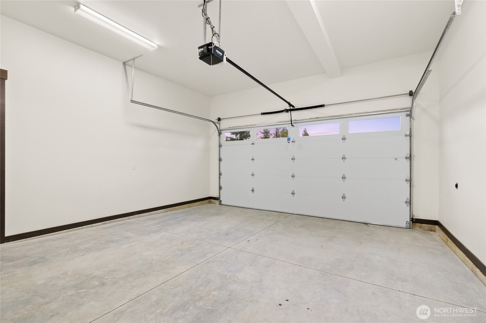 Spacious 2 car garage with separate side door to garbage room