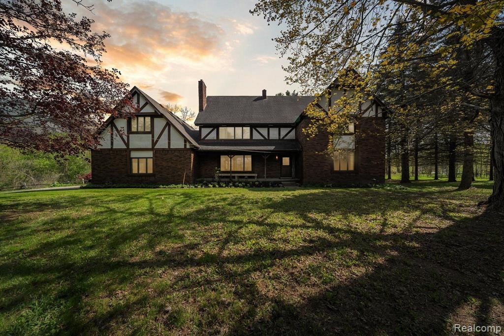 Welcome to this stunning, meticulously maintained, no expense spared, custom built tudor, offering over 5200 sq ft including a finished walk out basement & private entry “mother-in-law” area. This home can not be seen from the road, providing country living in the city, set on a private 5+ acre lot, located in highly sought after Brandon Twp with award winning schools. The home features 4 bedrooms, 3 1/2 bathrooms and multiple bonus/flex rooms that could be converted into additional bedrooms. The main floor boasts a large kitchen, breakfast nook, office/library with built-in oak shelves, dining room, living room, family room, 1/2 bath & laundry room. This home has high quality craftsmanship including slate flooring in the entry & 1/2 bath, bamboo flooring, 2 woodburning stoves with brick hearth, French doors, 6-panel pine doors and multiple storage closets. Expansive windows throughout allowing ample natural light. Upstairs master bedroom with large walk-in closet & en-suite bathroom, 3 additional generous bedrooms, 2 with a walk-in closet & 1 with 2 large double door closets share a full bath. The covered front porch as well as the back deck are great spaces to relax & enjoy the serene setting. Newer roof, furnace, appliances, wood floors & Andersen windows. Additionally, the property includes a three-story barn with over 2000 sq ft including an additional 2 car garage with cement floor, quality plywood floors, electricity, steel exterior & new metal roof 2022. The sky's the limit with the possibilities that this space could be used for. A separate 1 car garage/shed with carport is great for yard equipment & supply storage. Conveniently located near the Polly Ann Trail as well as shopping, dining & entertainment. Perfect for horse owners, the township permits 2 horses on 5 acres. 5 additional acres, split into 2, 2 1/2 acre lots available for sale as well. Easement in place on 1 lot for the driveway. An opportunity like this does not come along often, don’t miss out. Schedule your private showing today.