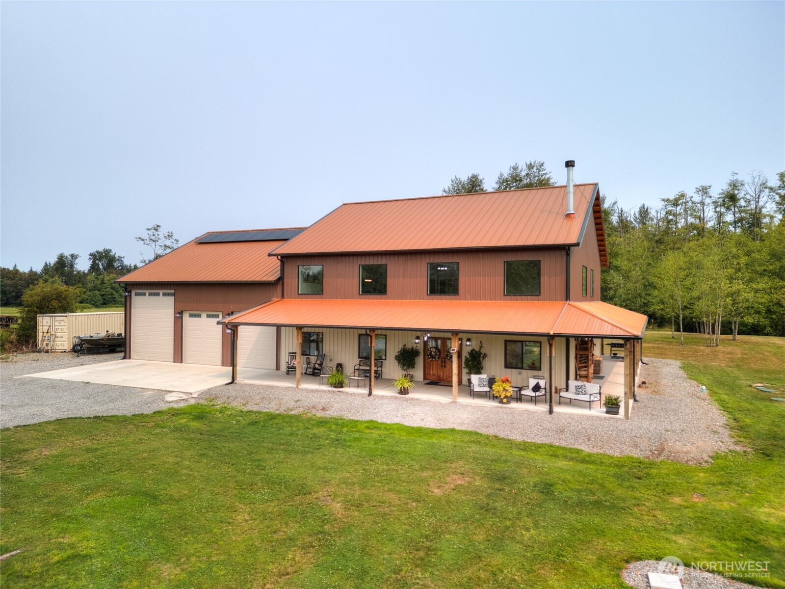 This custom home is more than beautiful—it's functional in every sense of the word! Filled with natural southern light and warm exposed timber beams, every feature was carefully considered to create a home that's as functional as it is beautiful. Soaring ceilings reaching nearly 24 feet and a stunning floor-to-ceiling fireplace anchor the great room, while the kitchen features custom cabinetry, granite countertops, a massive 9-foot granite island all that seamless flow into the dining area & great room. Offering 3,456 sf of thoughtfully designed living space, the main level of the home includes a private junior suite with its own bedroom and ¾ bath, a dedicated office and a bonus room ideal for a gym, media room or additional living space. Upstairs features a generous loft/family room, two additional bedrooms with a shared full bath, and a spacious primary suite with a large walk-in closet and a ¾ bath featuring dual vanities and a great walk-in tile shower. Energy efficient and built to last, this home features 2x6 construction with glue-laminated structural beams, radiant heat floors, solar panels, a seven-head mini-split system and an impressive 38' x 48' attached shop complete w/RV sewer, water & 50-amp hookup. Enjoy the covered wrap-around patio and 5 acres with endless possibilities for gardens, recreation, outdoor entertaining, or whatever you can imagine. Where quality craftsmanship & purposeful design are ready to welcome you home.