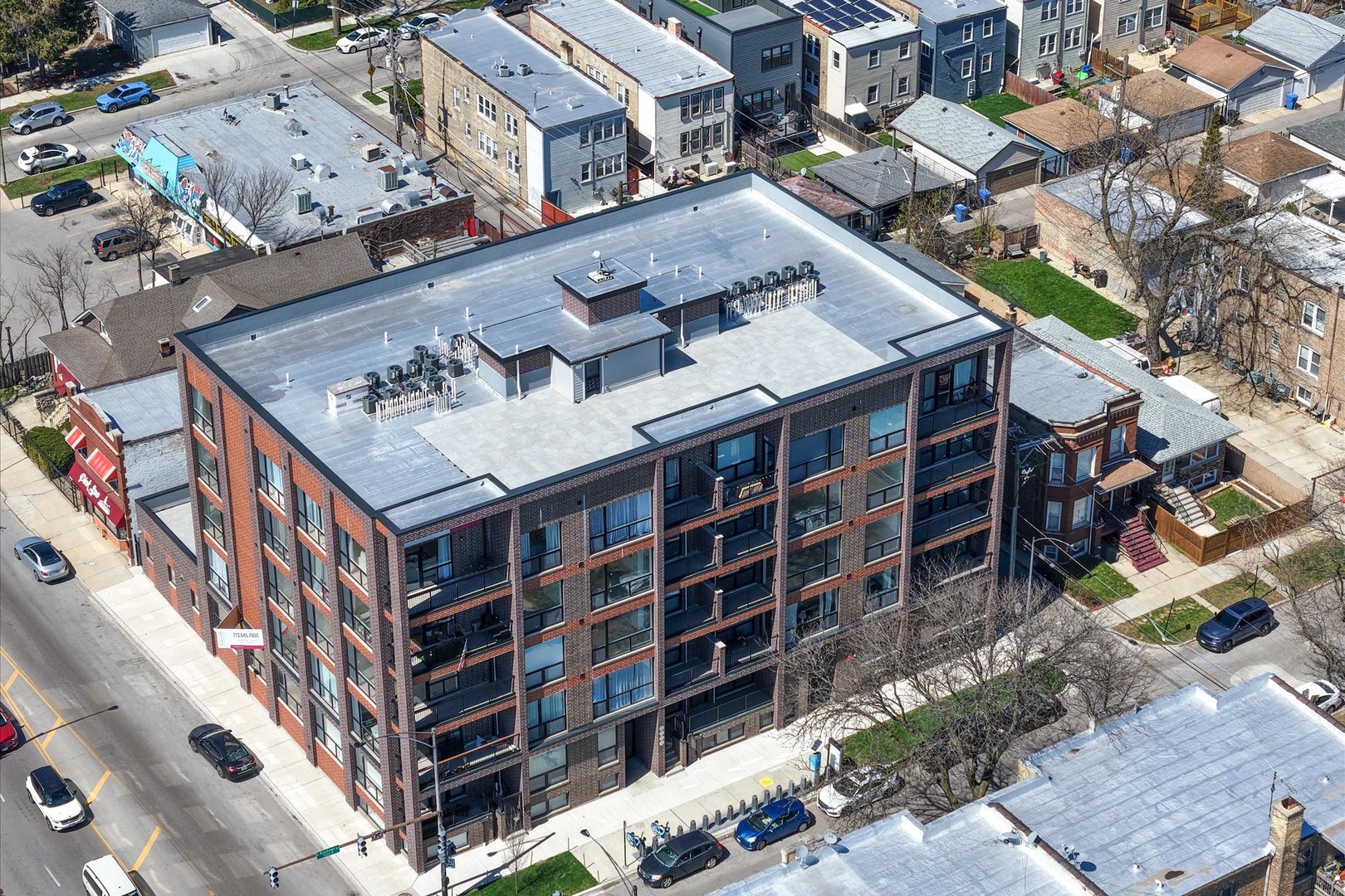 The last remaining penthouse-level residence in the building that features sweeping, unobstructed views of the downtown Chicago skyline from within the unit. Perched on the top floor of Avondale/Kilbourn Park's newest boutique condominium, this residence offers expansive sightlines through oversized windows that flood the home with natural light and frame the skyline from the moment you walk in. The open-concept living space is both dramatic and refined, anchored by a custom paneled feature wall and finished in solid ash-blonde hardwood flooring throughout. The kitchen is equally striking and functional, featuring quartz countertops, a full quartz island and backsplash, flat-paneled cabinetry, stainless steel appliances, and carefully selected statement lighting. The primary suite and second bedroom are thoughtfully designed for comfort and flexibility, while both bathrooms deliver a spa-like experience with porcelain-tiled walk-in showers and integrated built-in niches. Step outside to your private balcony-complete with a gas line for grilling-and take in uninterrupted skyline views that transition from glowing sunrises to the city illuminated at night. Just one level above, the expansive shared rooftop deck offers additional space to relax and entertain against the backdrop of downtown Chicago.  Ideally located between Avondale and Logan Square with convenient access to the expressway and public transit, this penthouse combines elevated design, modern convenience, and a view that truly sets it apart. Garage parking (Space #22) equipped for EV charging included.